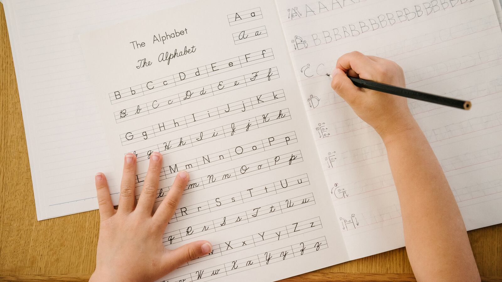 A child practices writing the alphabet.
