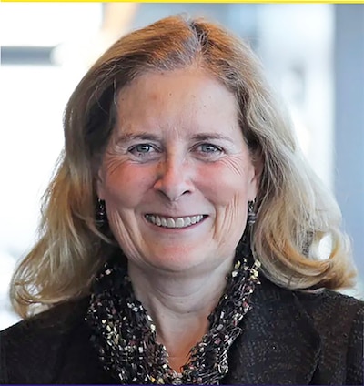 A woman with short blonde hair poses for a portrait.