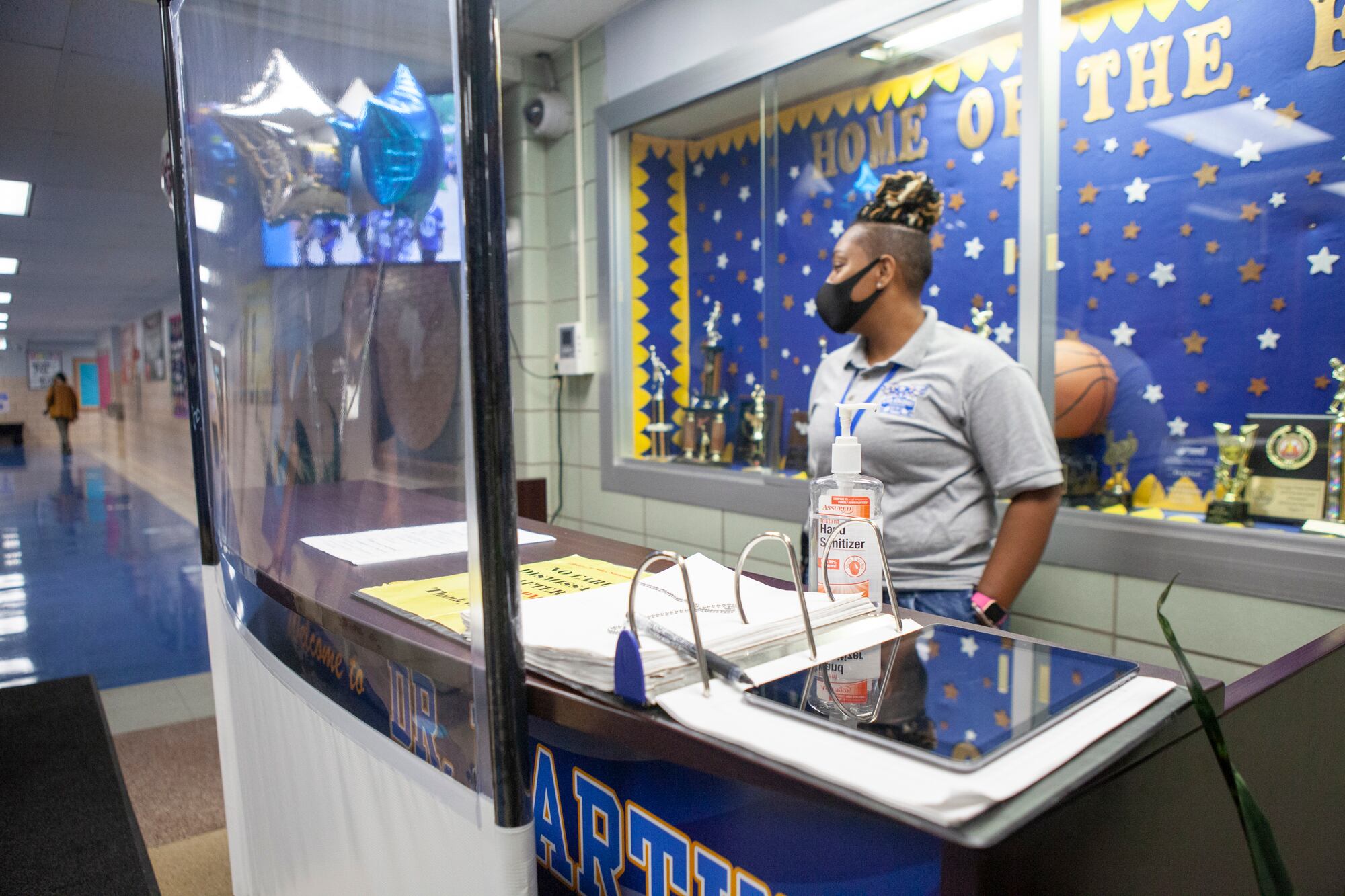 A health screening station with balloons that read welcome back.