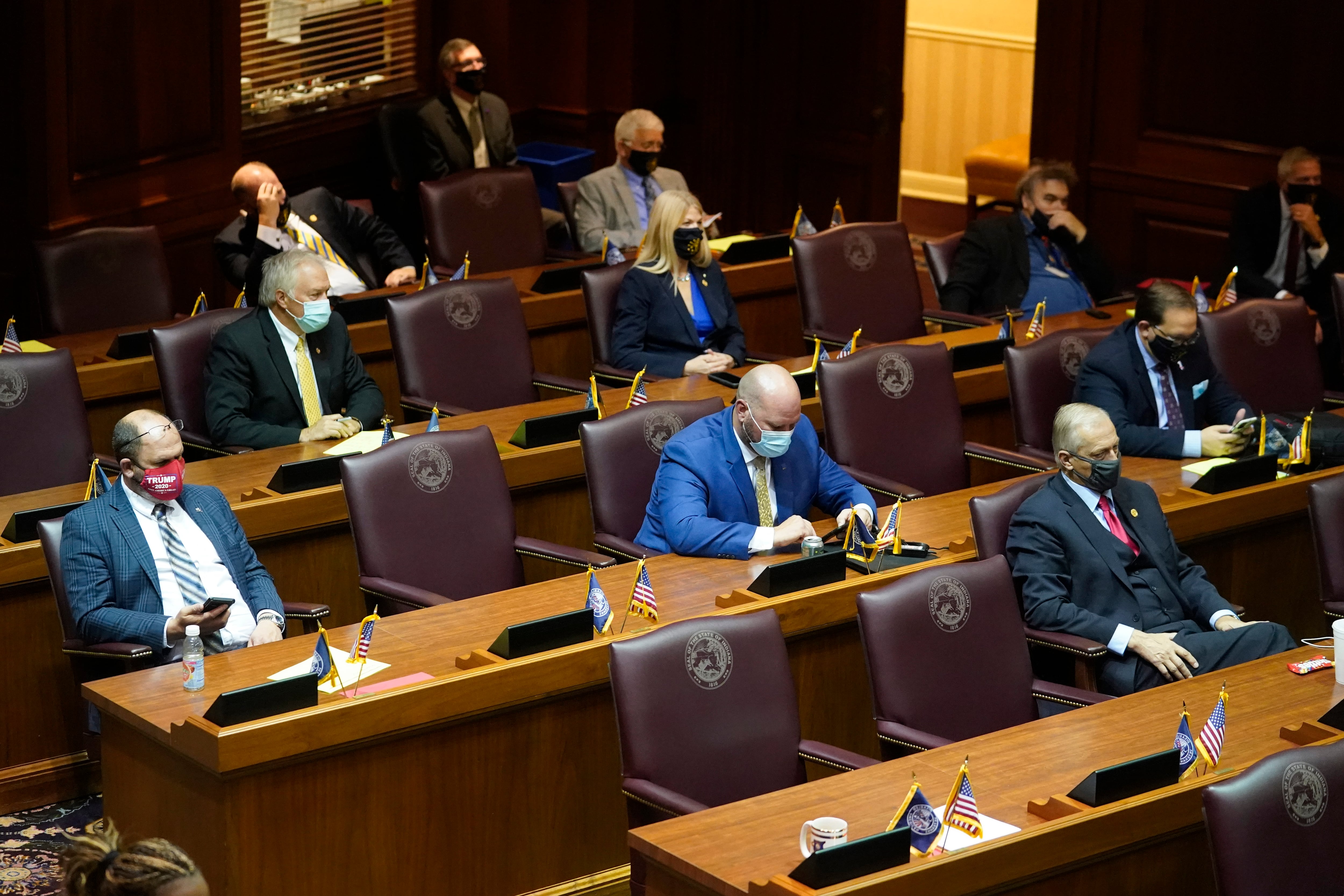Masked lawmakers sit spaced apart at their desks in the Indiana Senate,
