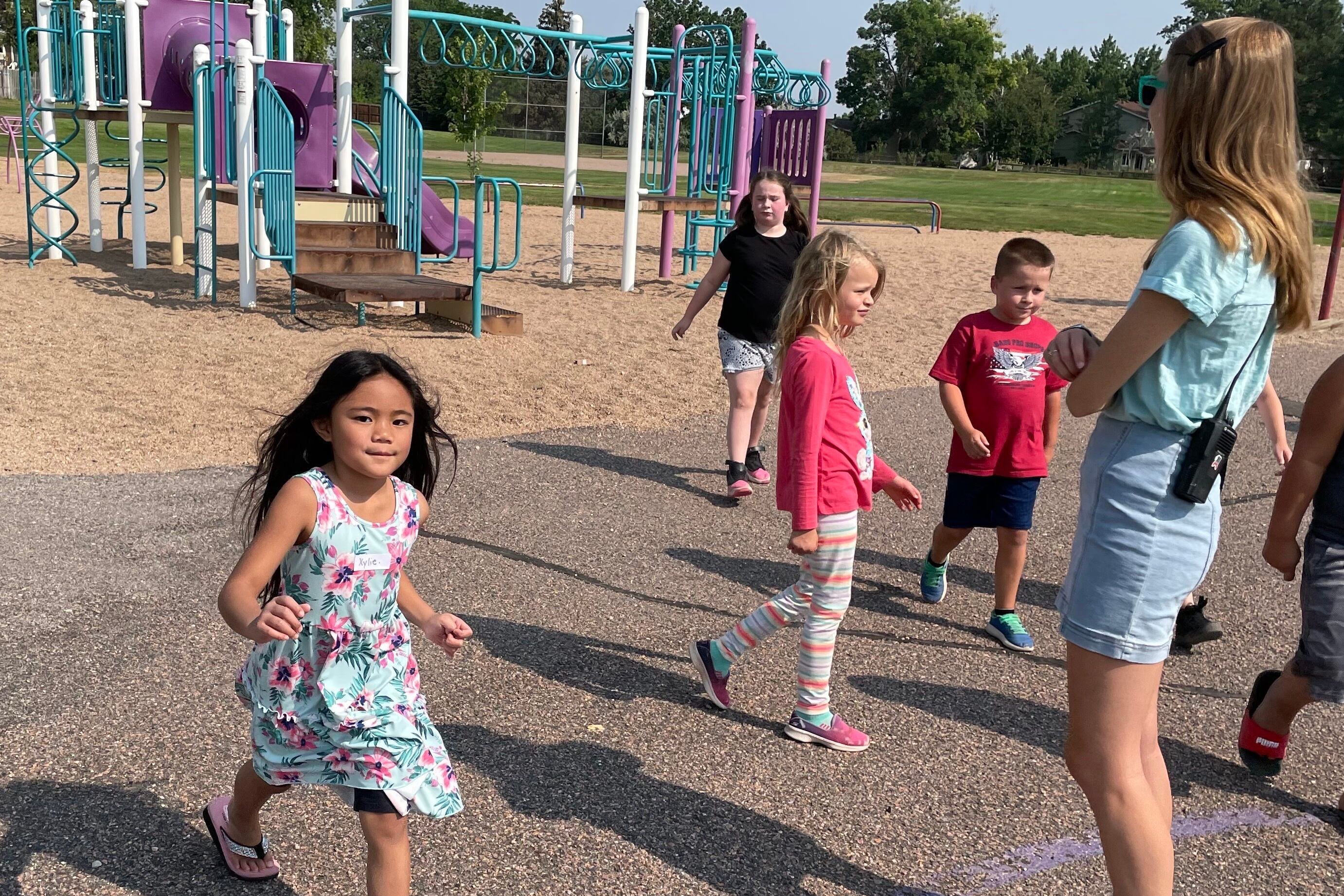 Young children play on a blacktop during recess at a school summer program.