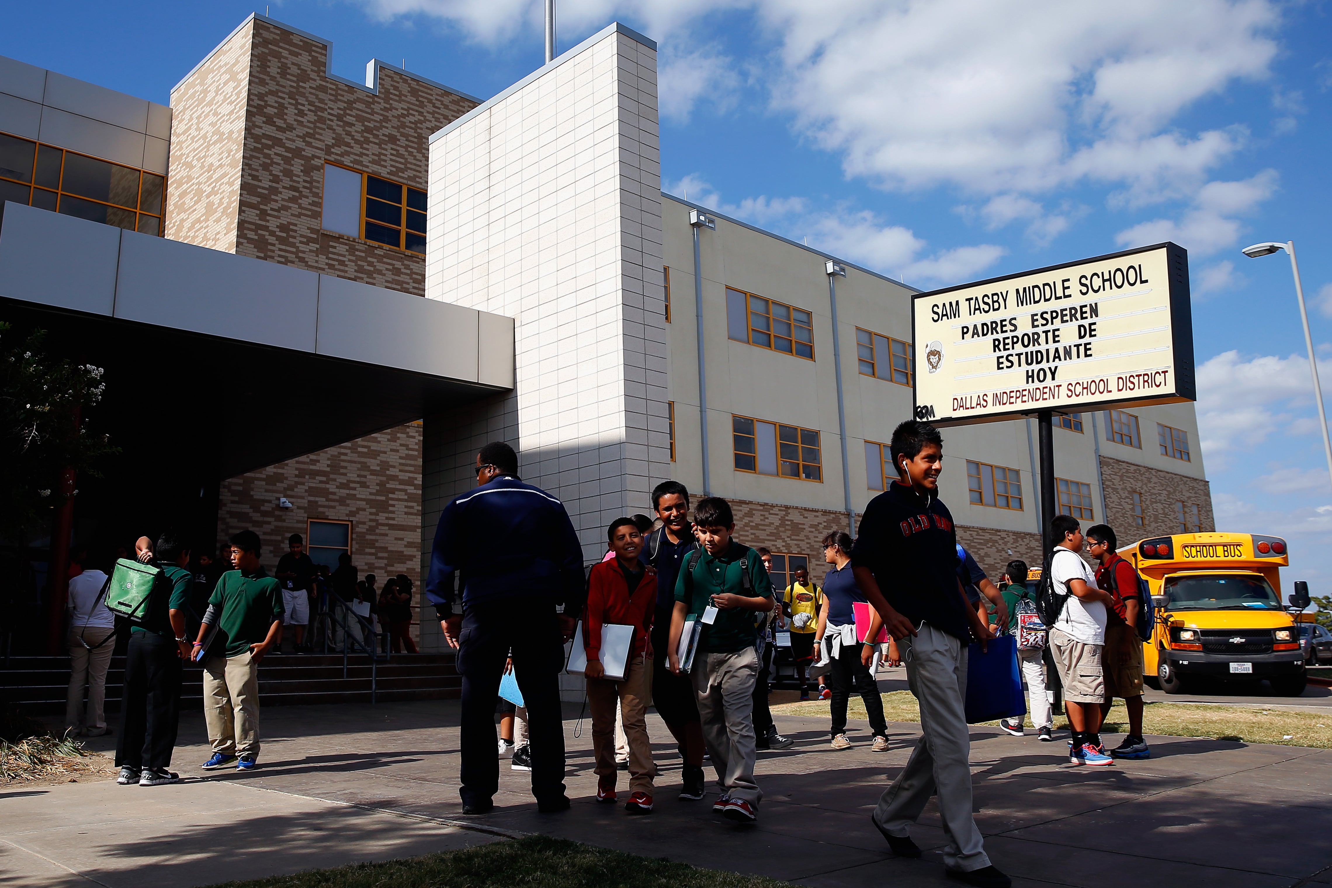 Students gather outside of Sam Tasby Middle School on a bright, sunny day.