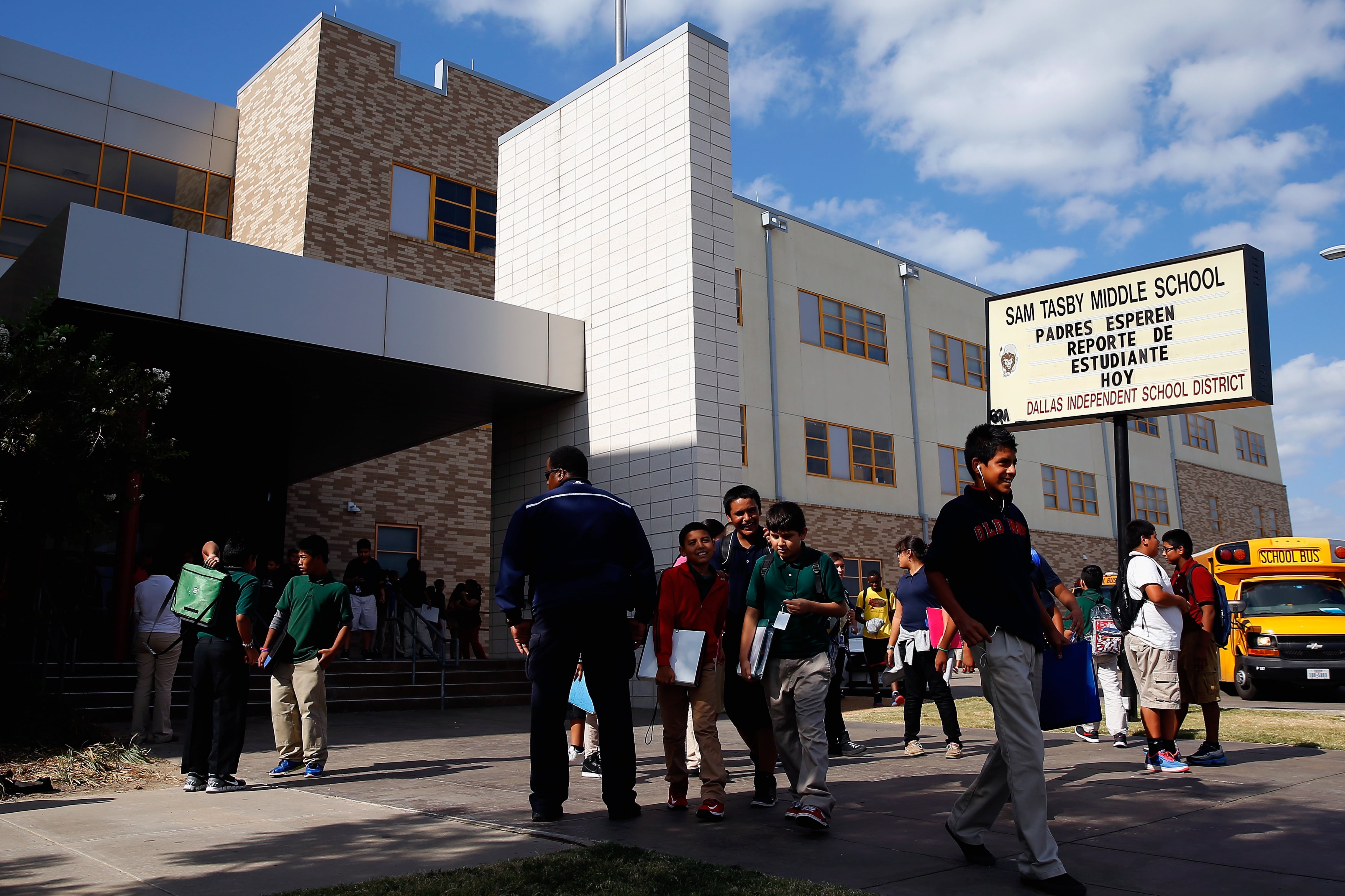 Students gather outside of Sam Tasby Middle School on a bright, sunny day.