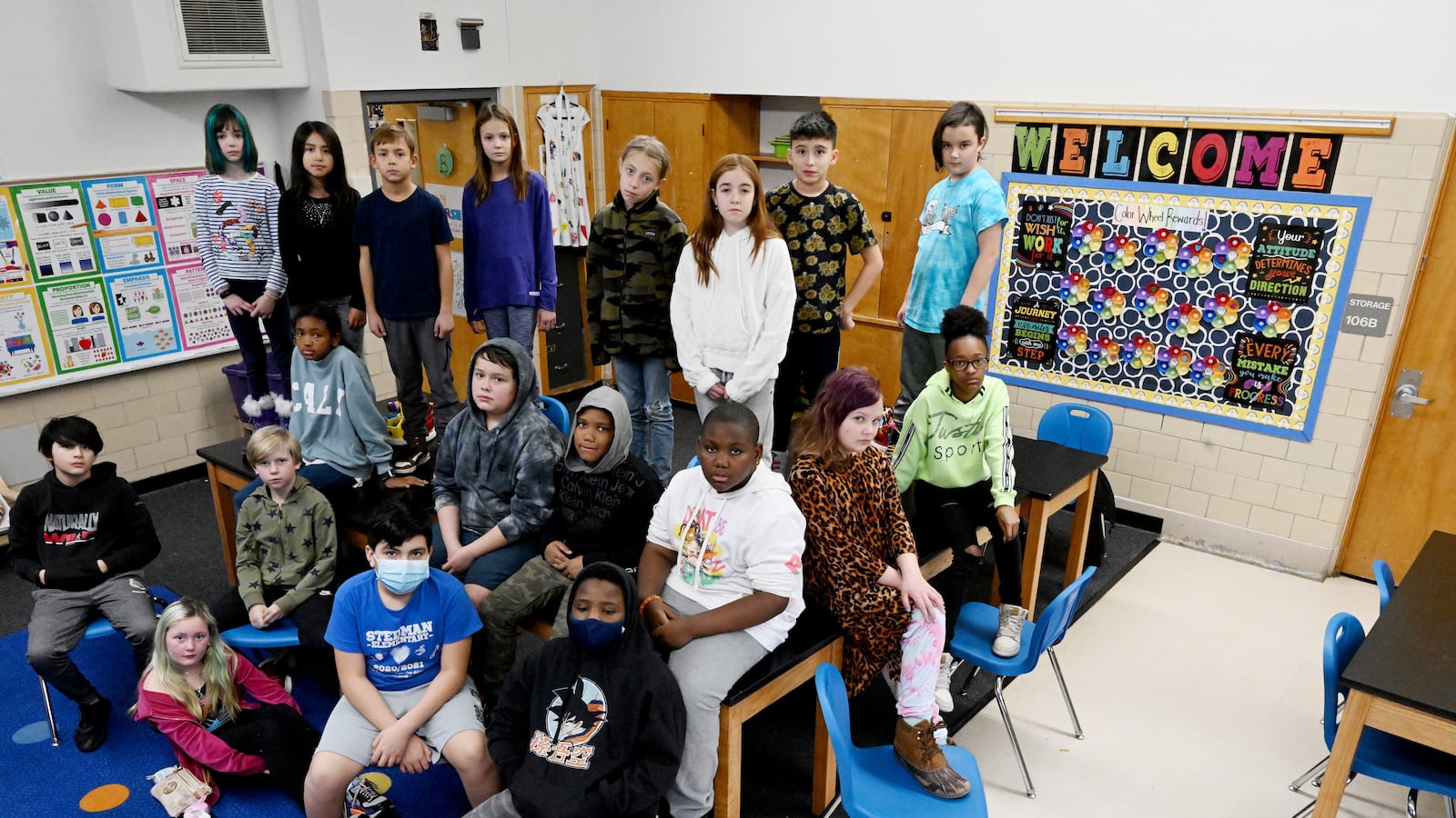 An elementary class poses for a portrait in a classroom.