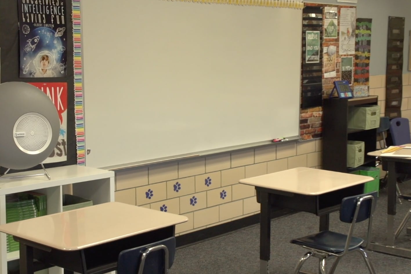 A Synexis sphere device that spread hydrogen peroxide sits on a shelf in an empty classroom.