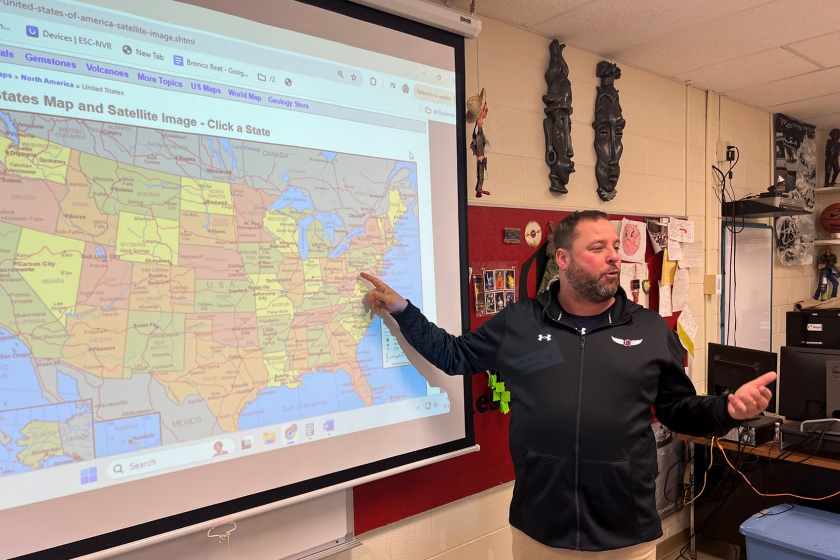 A photograph of a man pointing to a map during class.