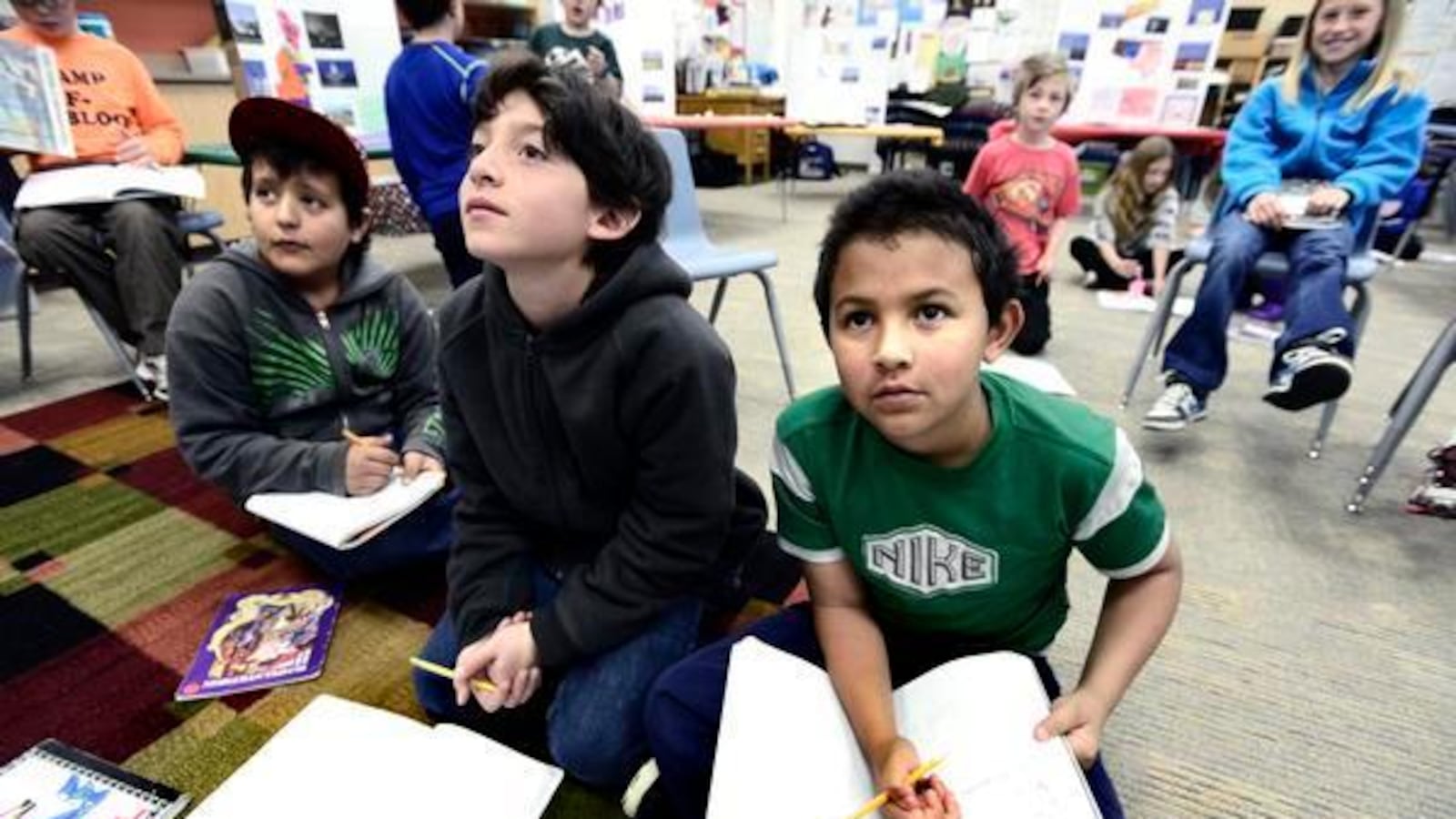 From left to right Harian Aldama, Miguel Silva, and Julian Aldama look over a reading and writing lesson on the classroom board in Jessica Cirelli's third-grade class at Escuela Bilingue Pioneer Elementary in Boulder on Tuesday morning May 7, 2013. (Denver Post file)