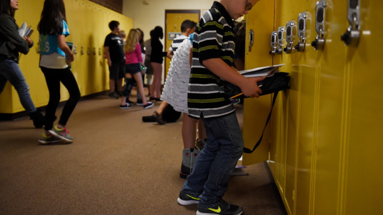 Ryan Kilburn checks his schedule before leaving a bank of lockers at Overland Trail Middle School on August 17, 2017, in Brighton, Colorado. (Photo by Seth McConnell/The Denver Post)