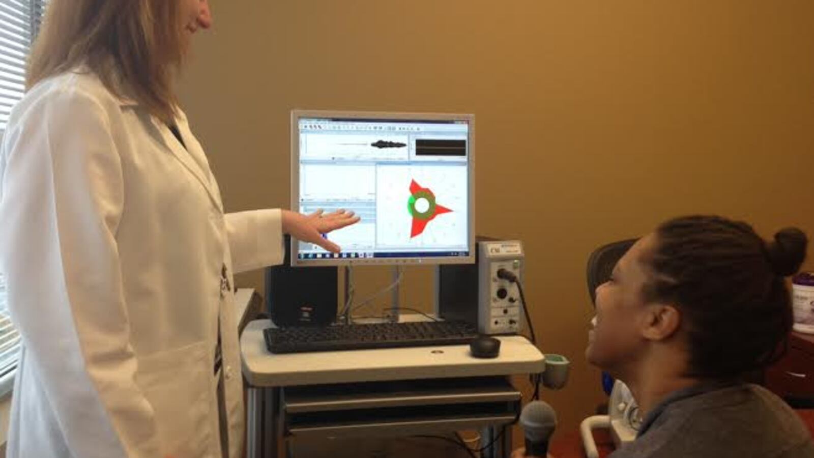 A vocal therapist works with a colleague.