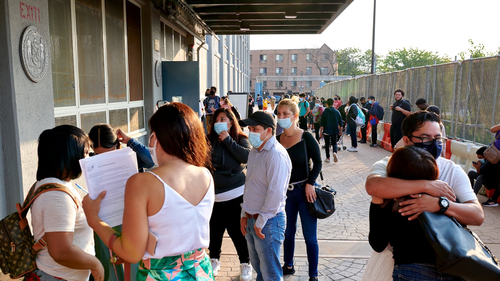 Students embrace as several others make their way into Pan American High School on the first day of classes.