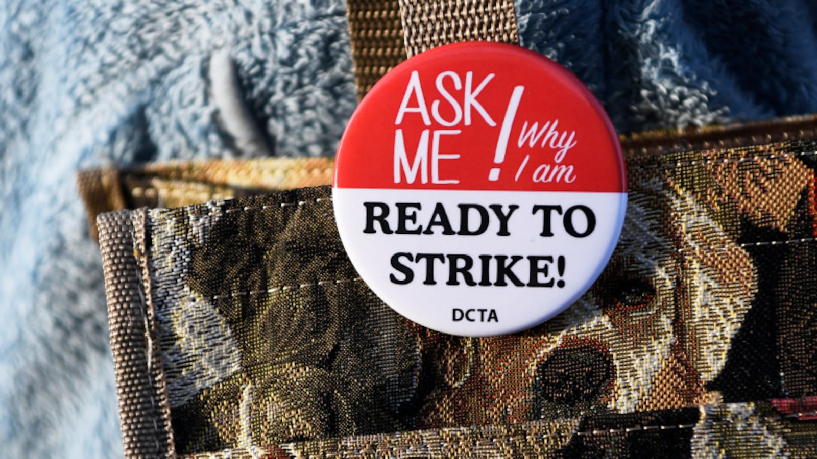 Denver teacher Kimberly Duran wears a button that says, "Ask me why I am ready to strike."