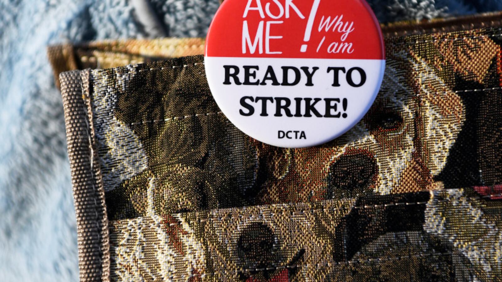 Denver teacher Kimberly Duran wears a button that says, "Ask me why I am ready to strike."