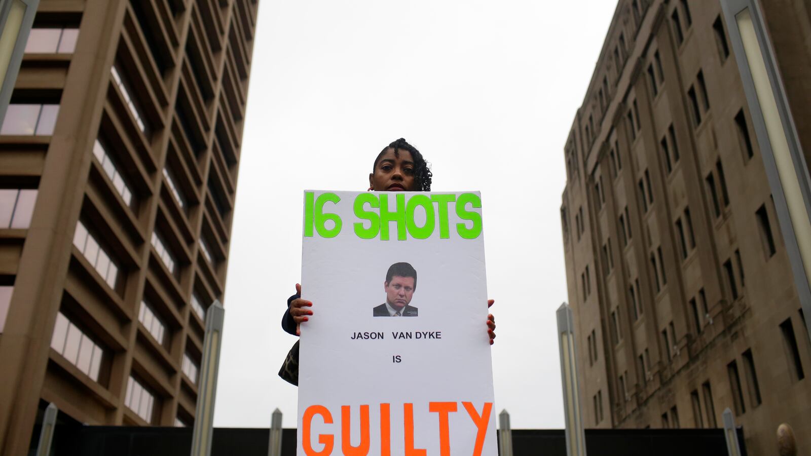 A woman holds a sign outside the courthouse after a murder verdict is handed down in the trial of Chicago Police Officer Jason Van Dyke.