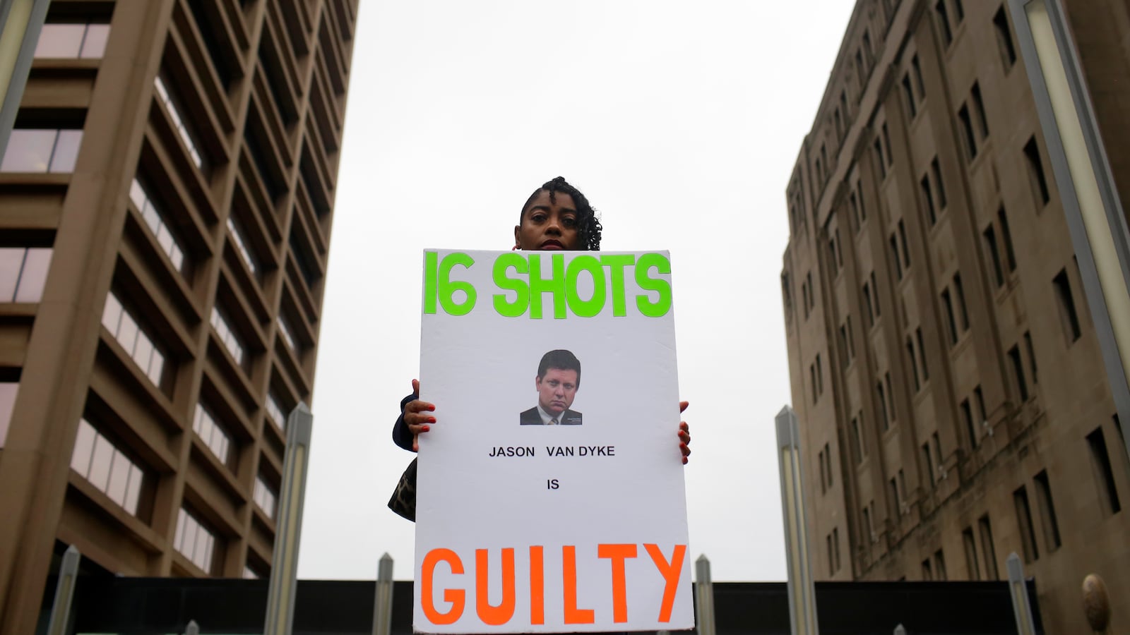 A woman holds a sign outside the courthouse after a murder verdict is handed down in the trial of Chicago Police Officer Jason Van Dyke.