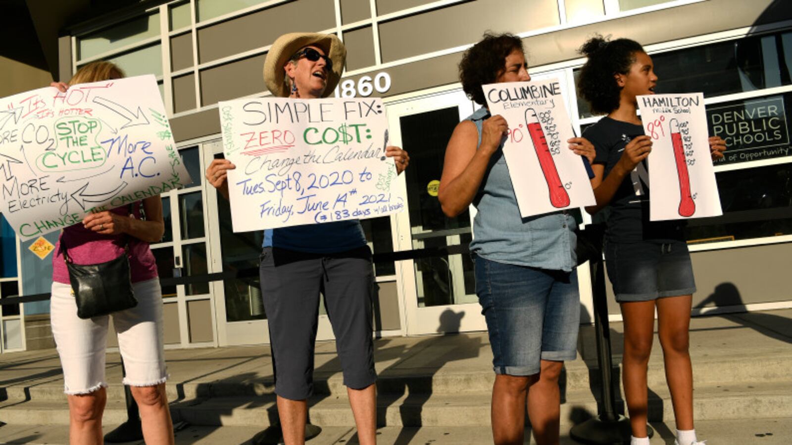 Margaret Bobb, second from left, a retired Denver teacher, holds a sign to protest hot classrooms in August 2019.