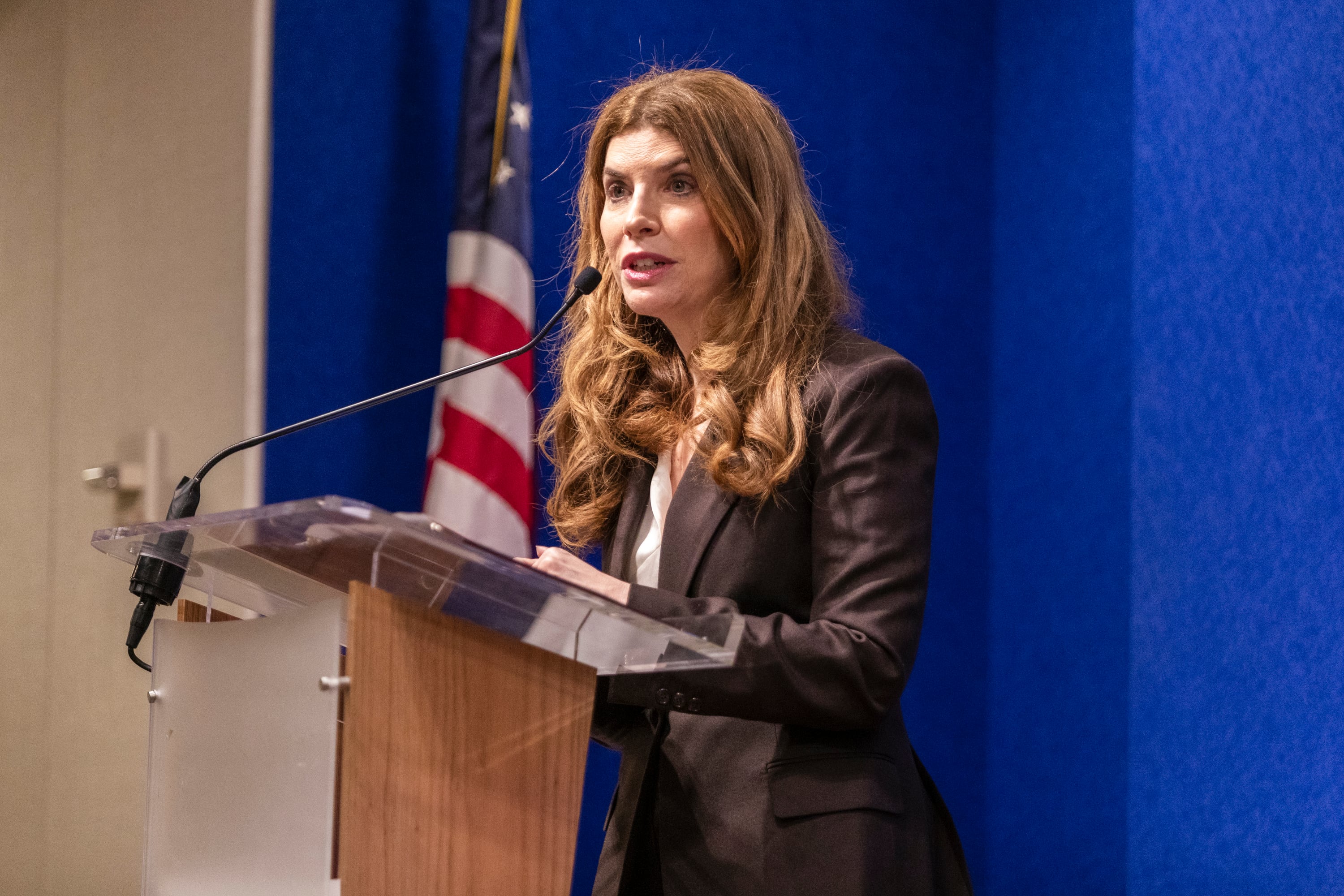 A white female speaking at a podium.