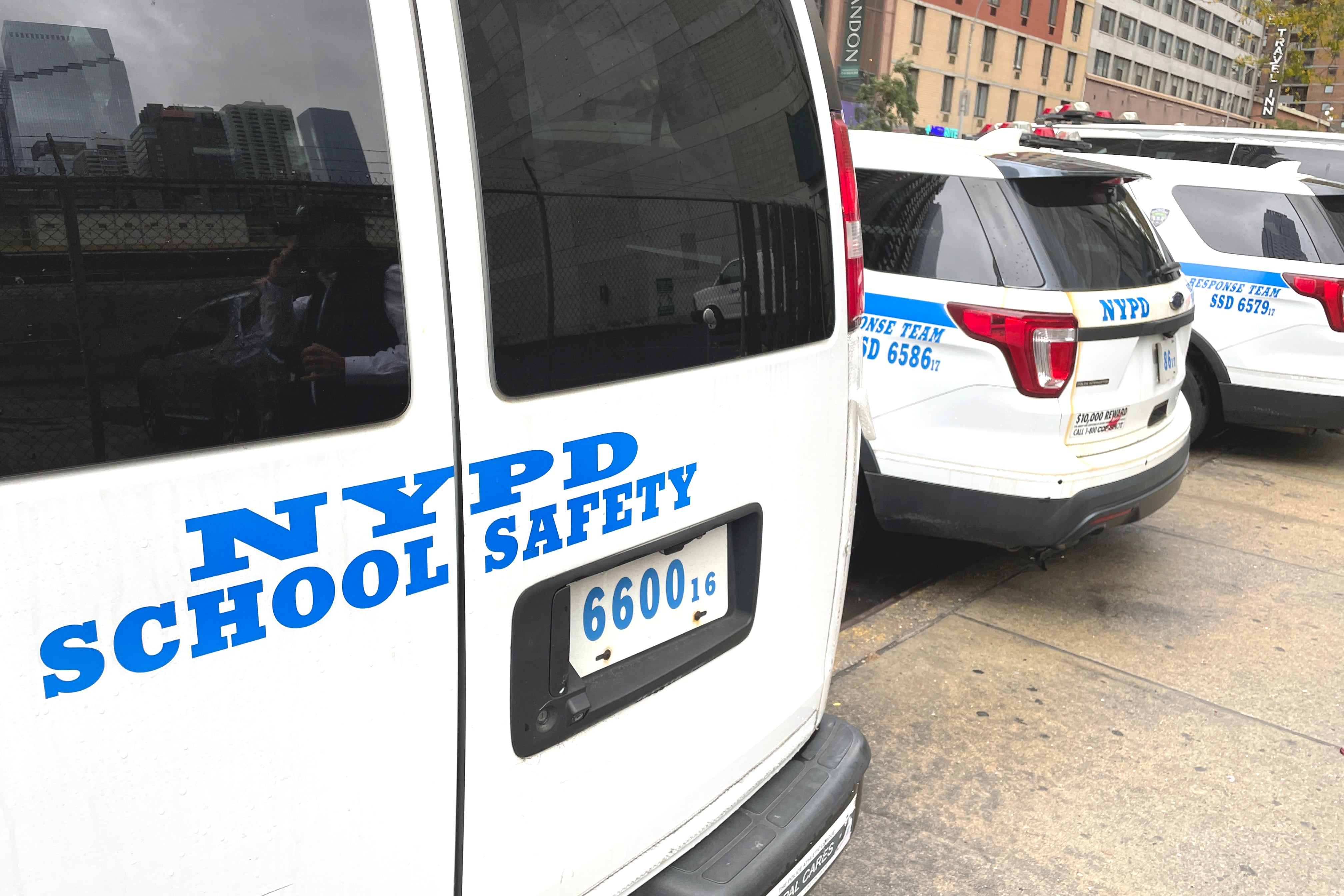 Safety vans and cars sit in a line.