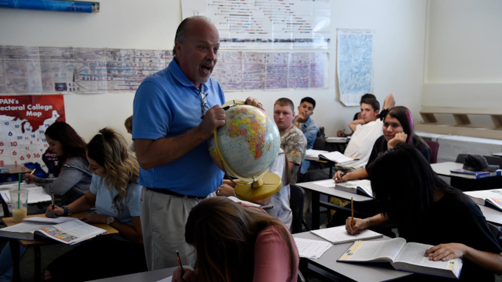Tom Ritter holds up a globe as he teaches his students during a Political Science class in August of 2017 at Brighton High School. (Photo by Seth McConnell/The Denver Post)