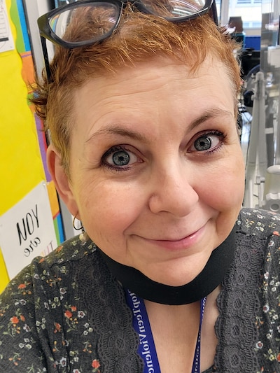 A woman with glasses on her head take a selfie.