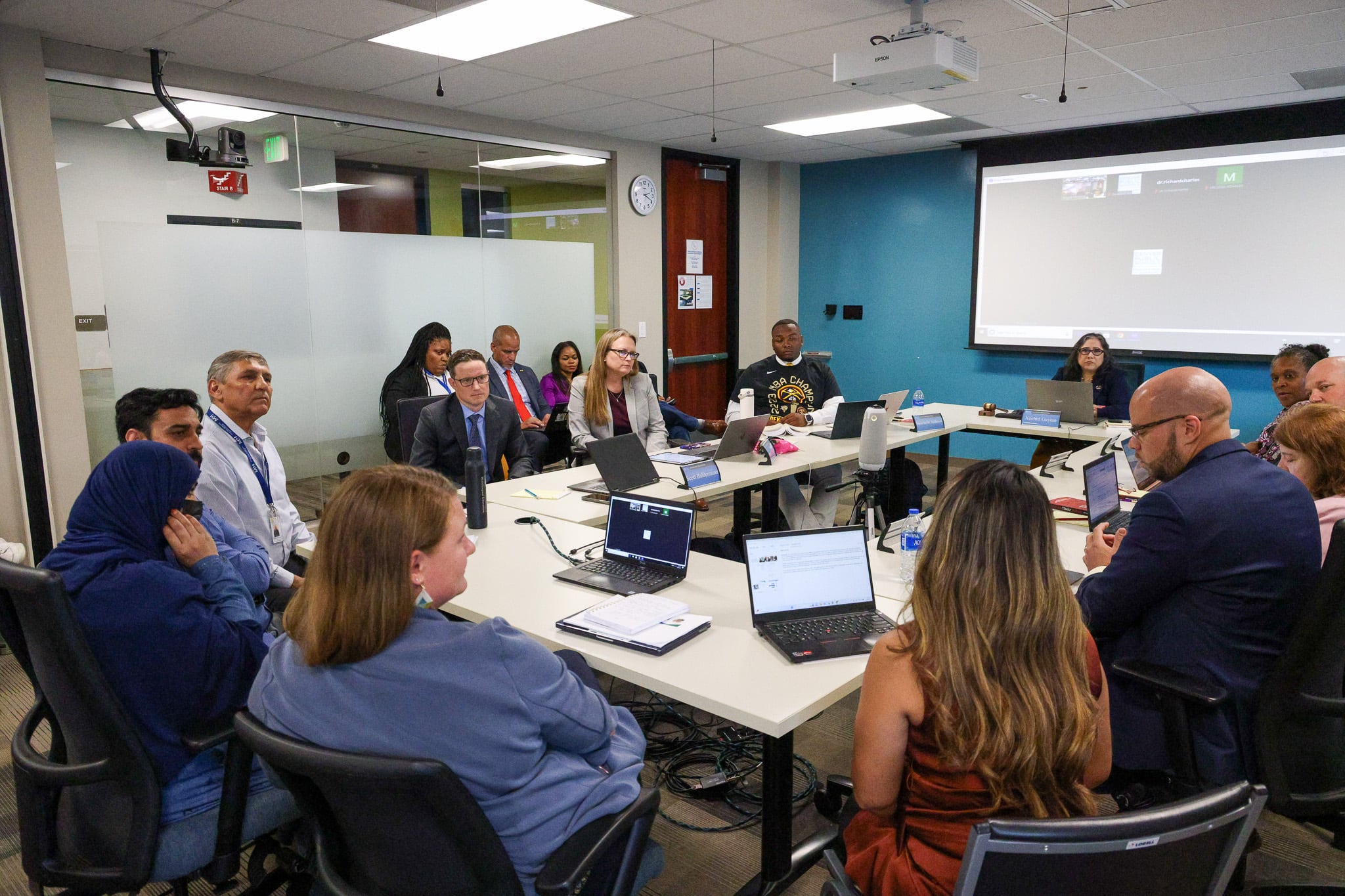 The Denver school board sits around a table in a room at Denver Public Schools headquarters.