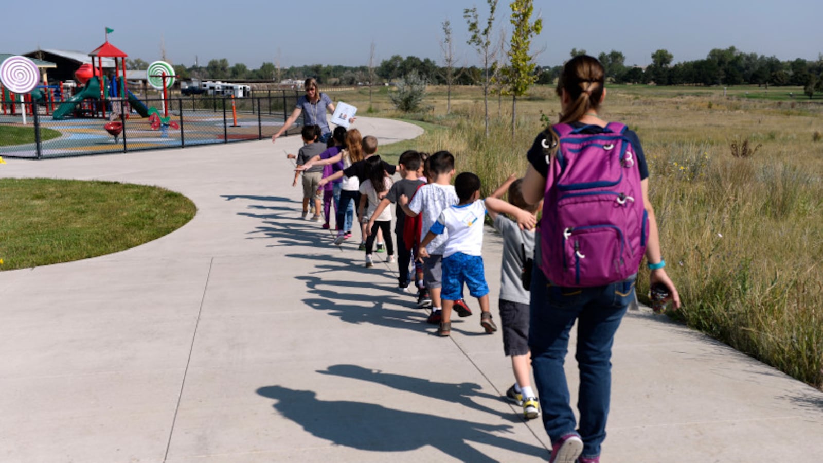 An early childhood teacher leads her class out onto the playground in Aurora in 2017.