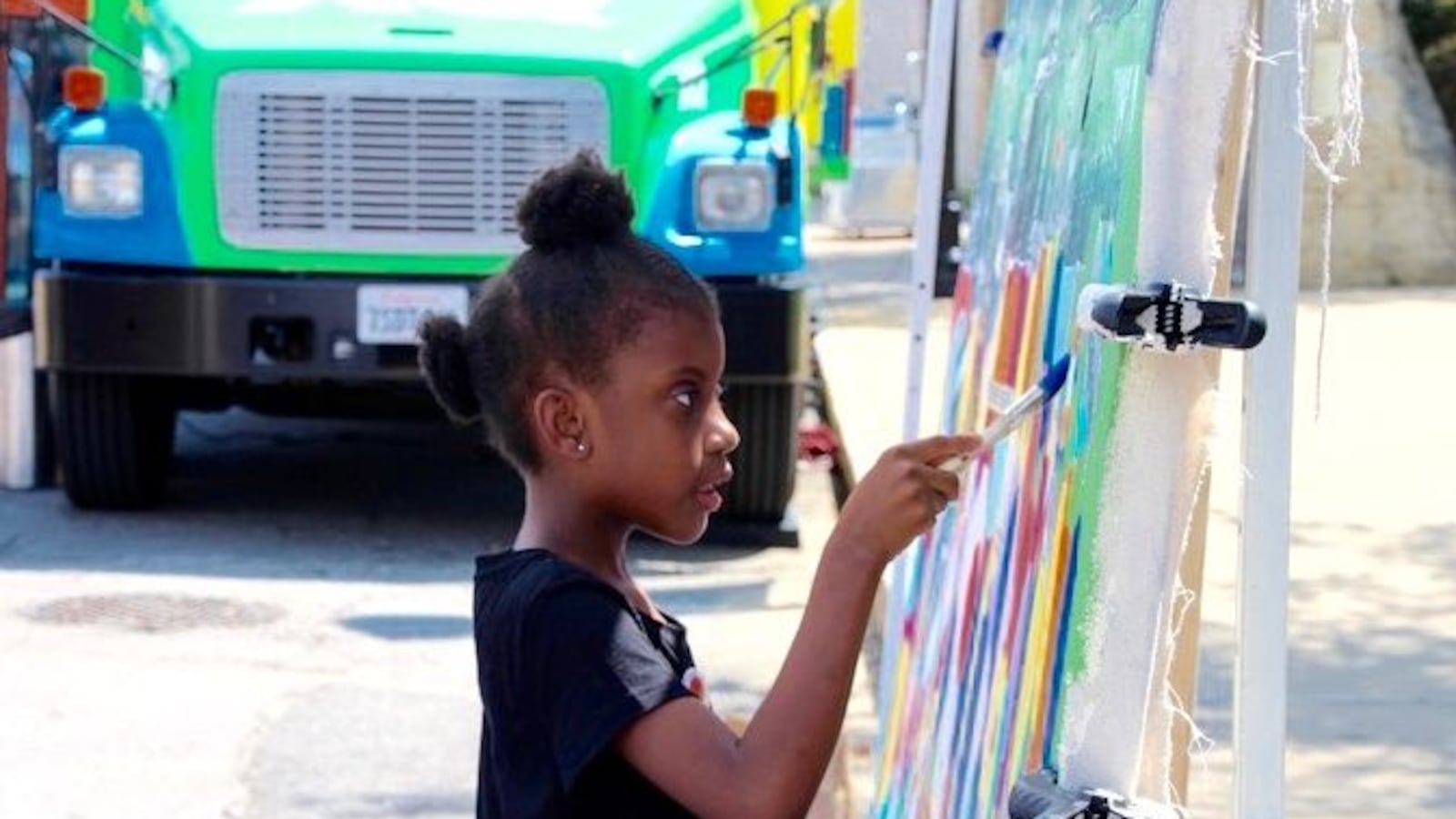 Gabrielle Colburn, 7, adds her artistic flair to a mural in downtown Memphis in conjunction with the XQ Super Schools bus tour in June. (Caroline Bauman)