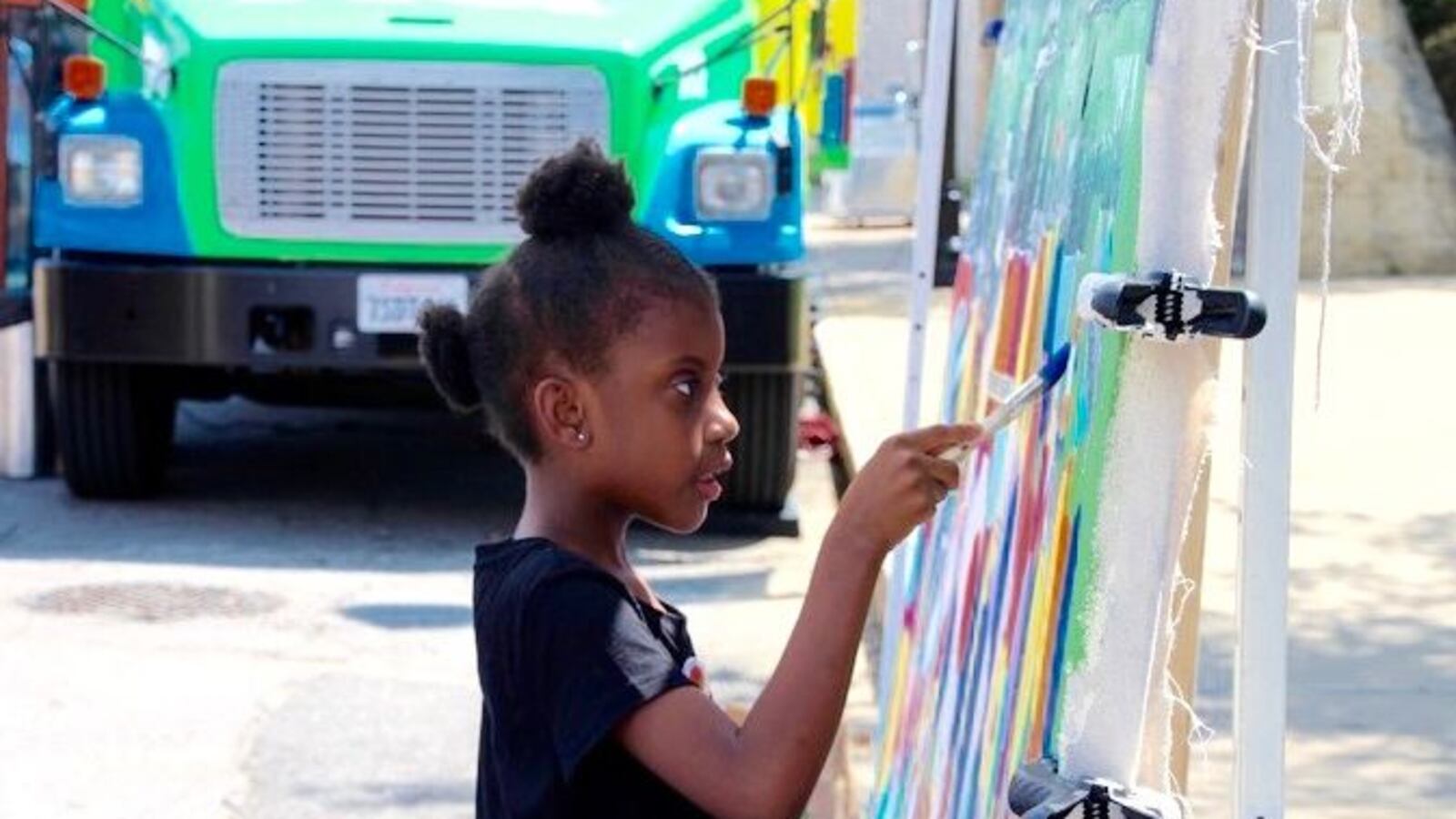 Gabrielle Colburn, 7, adds her artistic flair to a mural in downtown Memphis in conjunction with the XQ Super Schools bus tour in June. (Caroline Bauman)