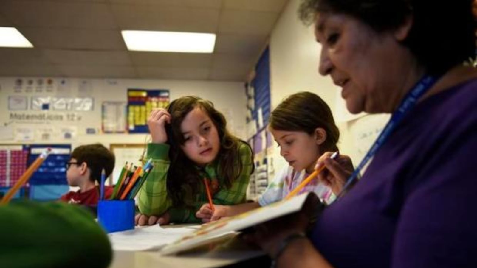 Victoria Tisman, 8, left, works with paraprofessional Darlene Ontiveros on her Spanish at Bryant-Webster K-8 school in Denver.