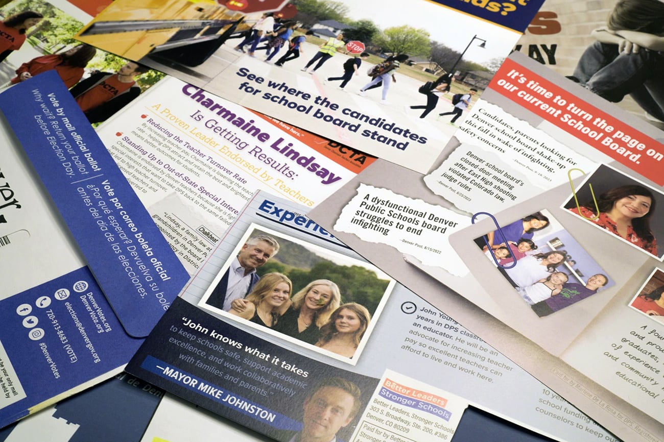 Campaign mailers spread out on a table.