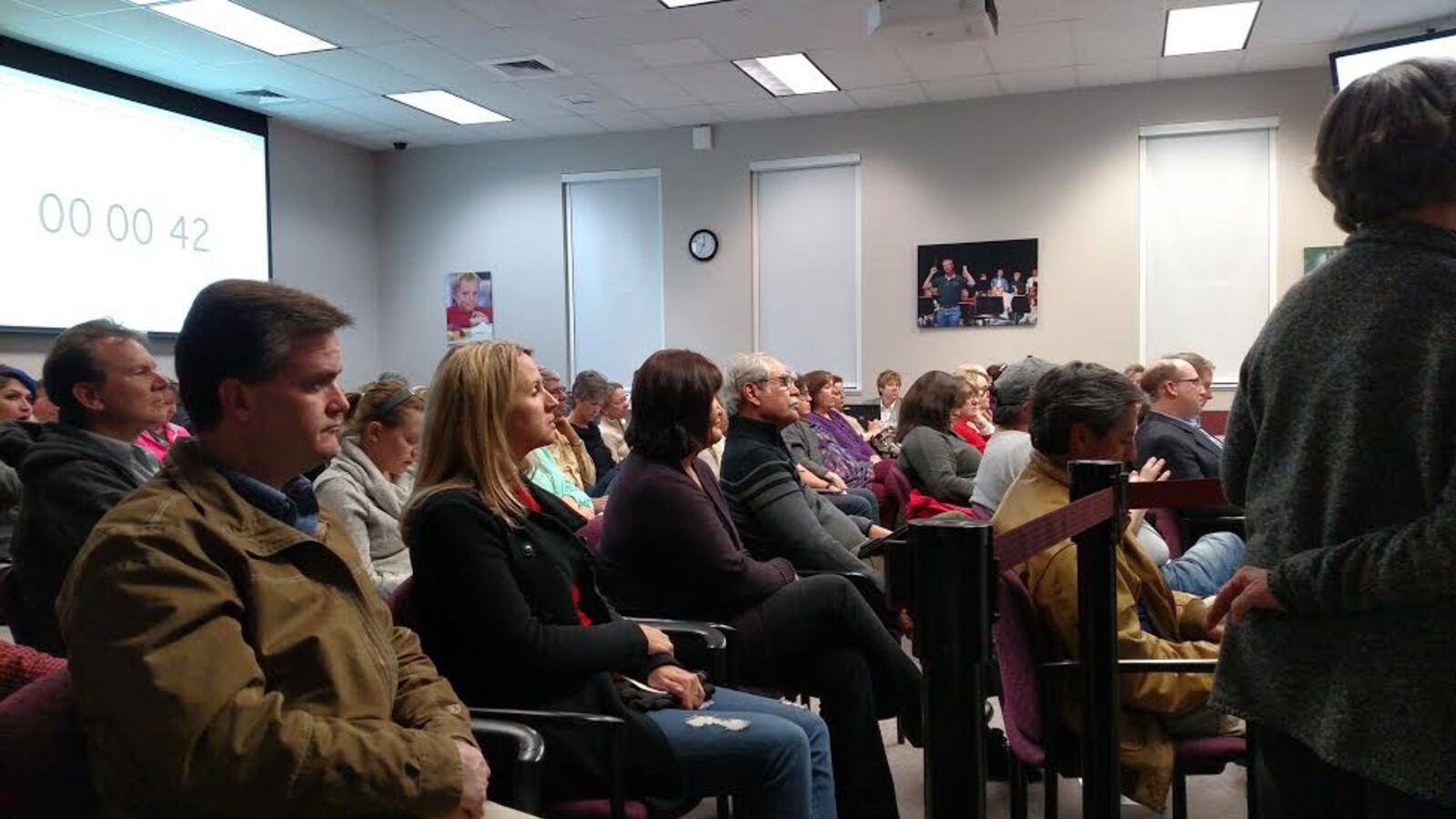 A room full of people sitting in chairs in rows.