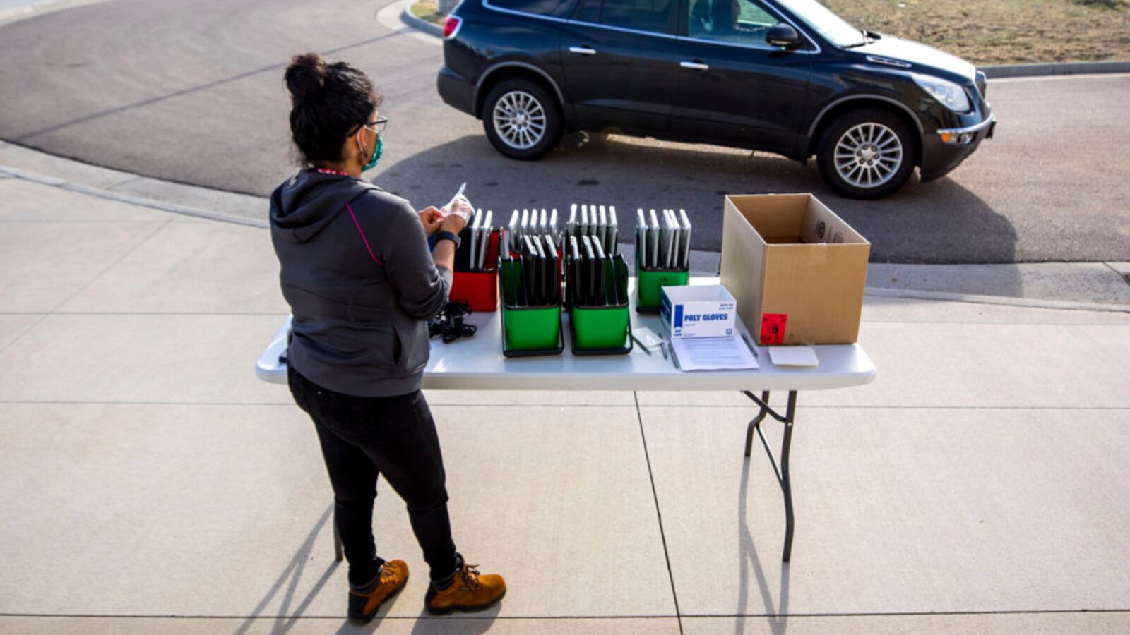 Staff distribute laptops to families at Denver’s Joe Shoemaker School on March 25, 2020, as schools prepare for remote learning.
