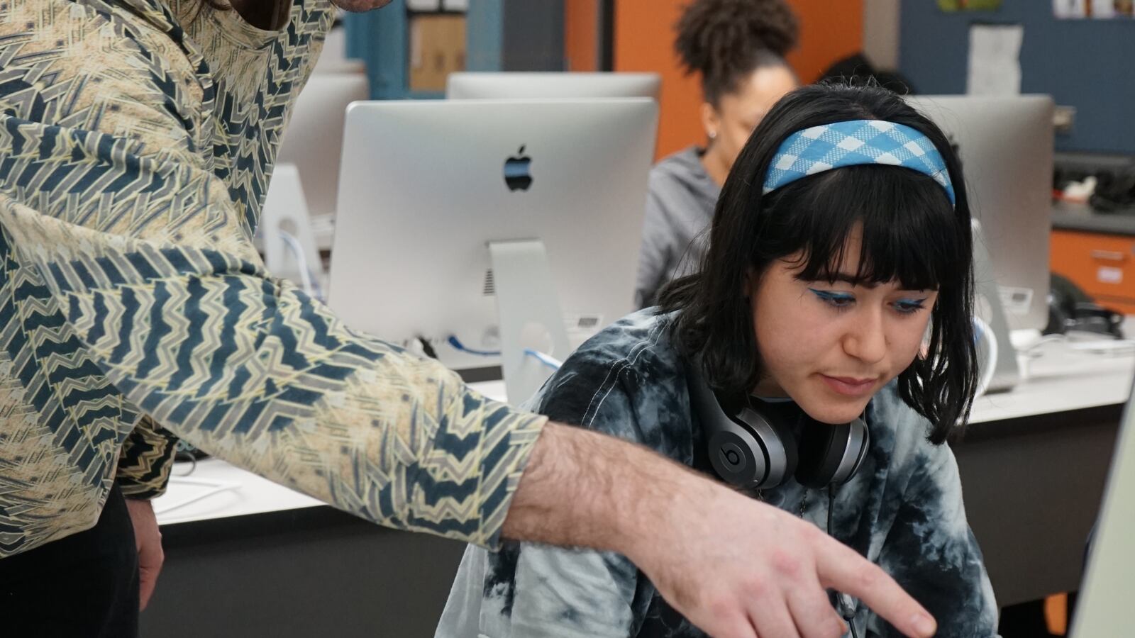 Jake Myers works with student Leni Bryan on a digital media assignment.