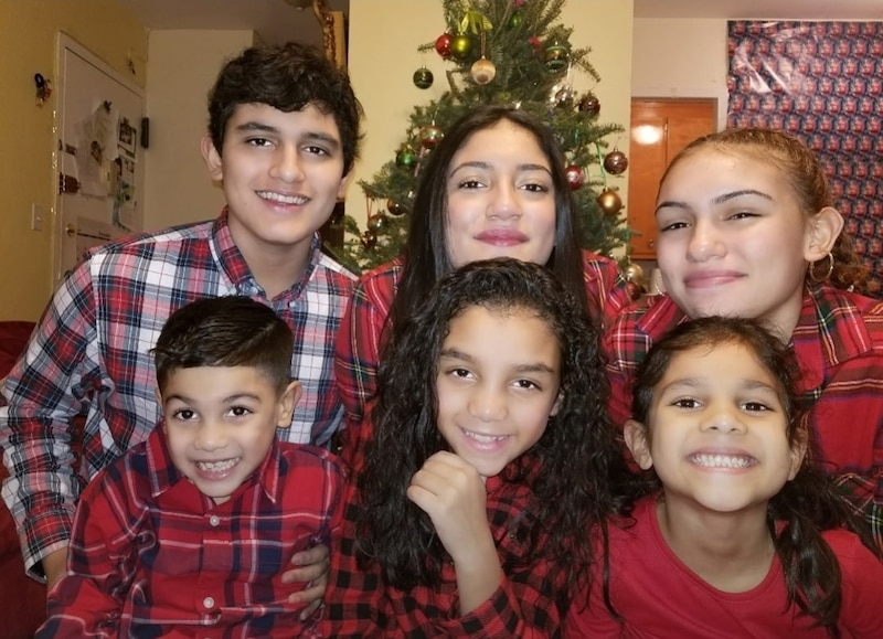 Six children wearing red stripped pajamas pose for a photograph all looking directly at the camera.