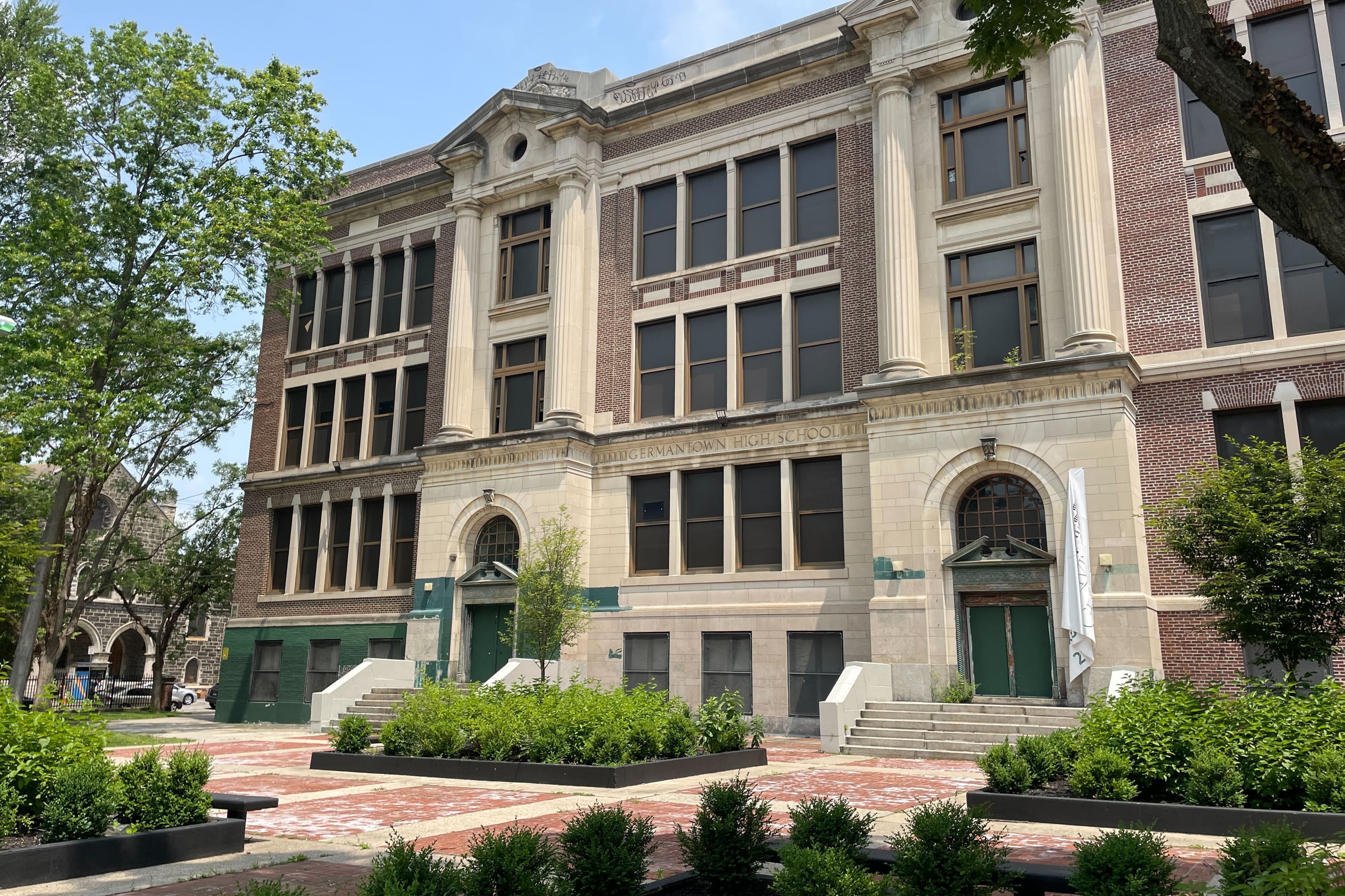 The outside of a large brick and stone building on a sunny day.