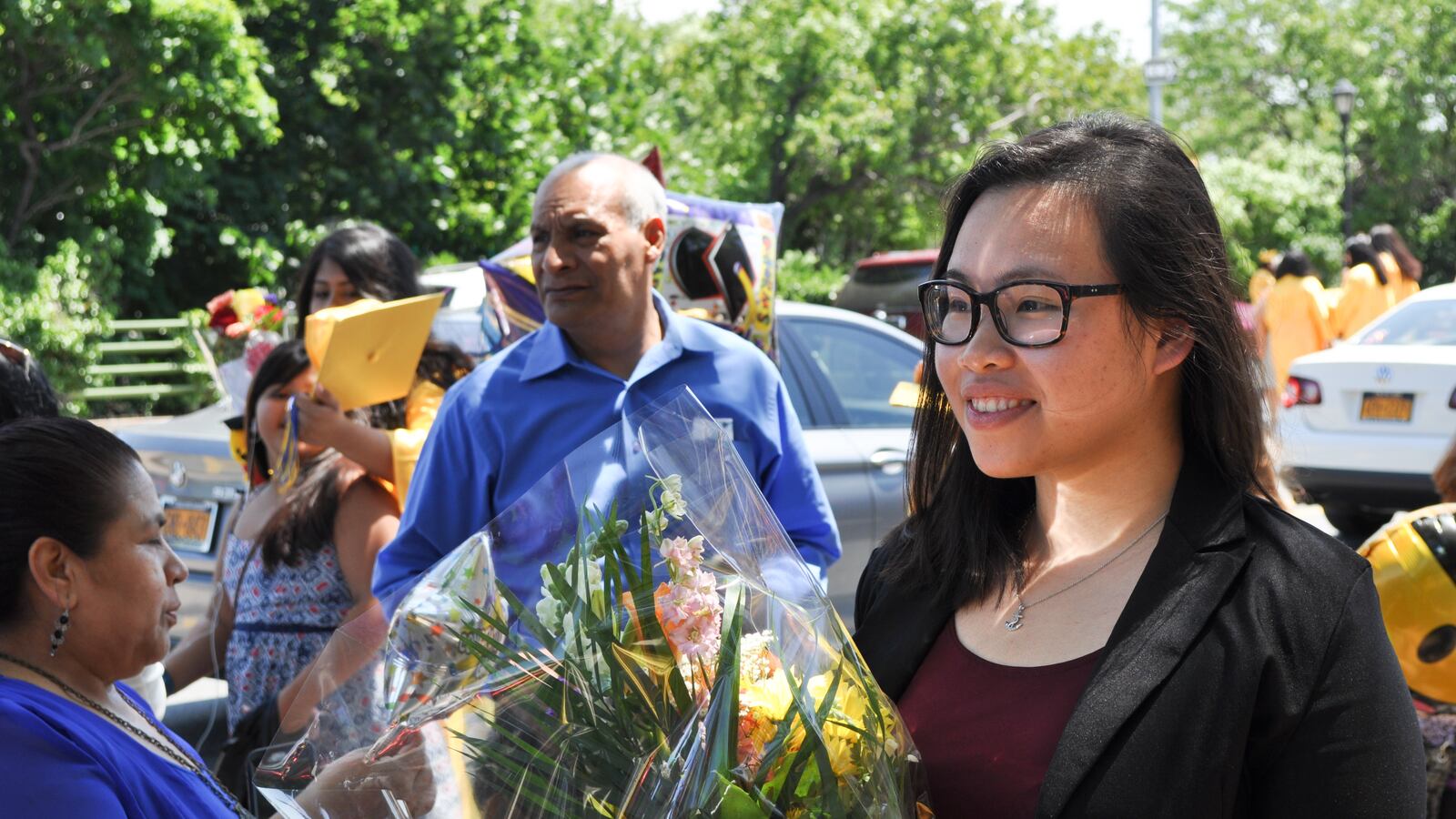 Qingmei Wu looks on as M.S. 88 students and parents gather for pictures after the graduation ceremony on Wednesday morning.