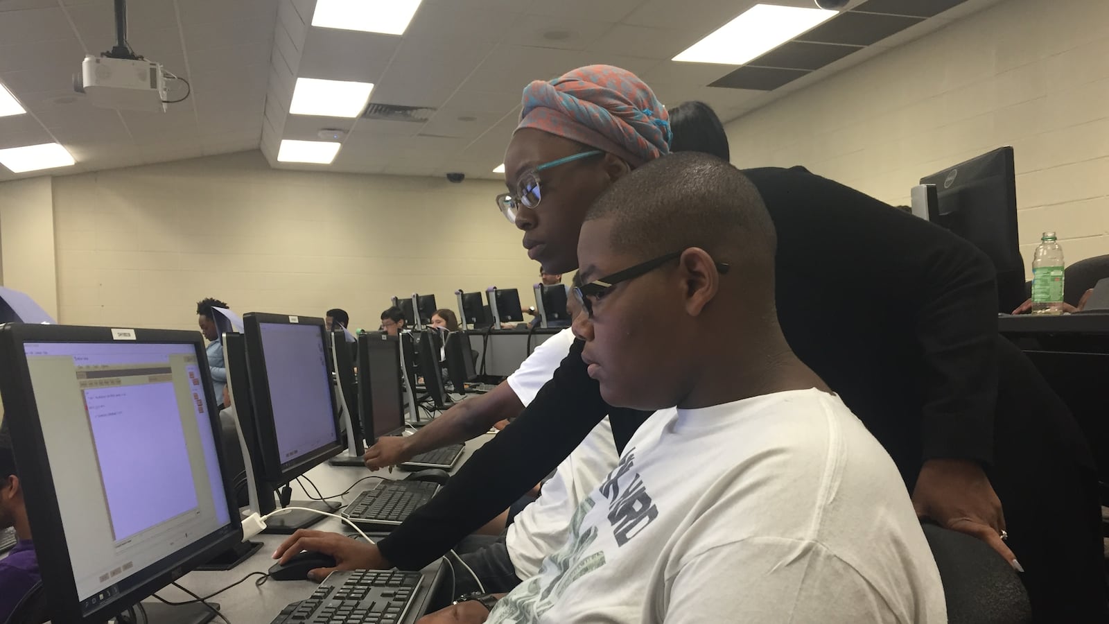 Joshua Williams, a student at Central High School, learns about coding with the help of Terricka Muhammed, a teaching assistant at the University of Memphis.