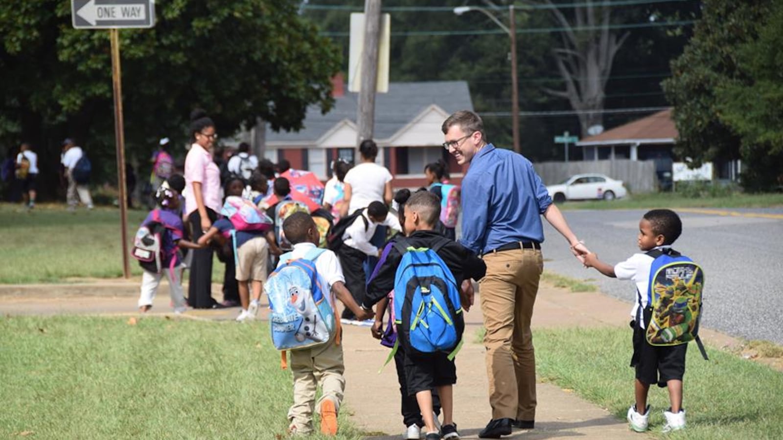Teacher Carl Schneider walks children home in 2015 as part of the after-school walking program at Whitney Achievement Elementary School in Memphis. This photograph went viral and inspired a First Person reflection from Schneider in 2017.