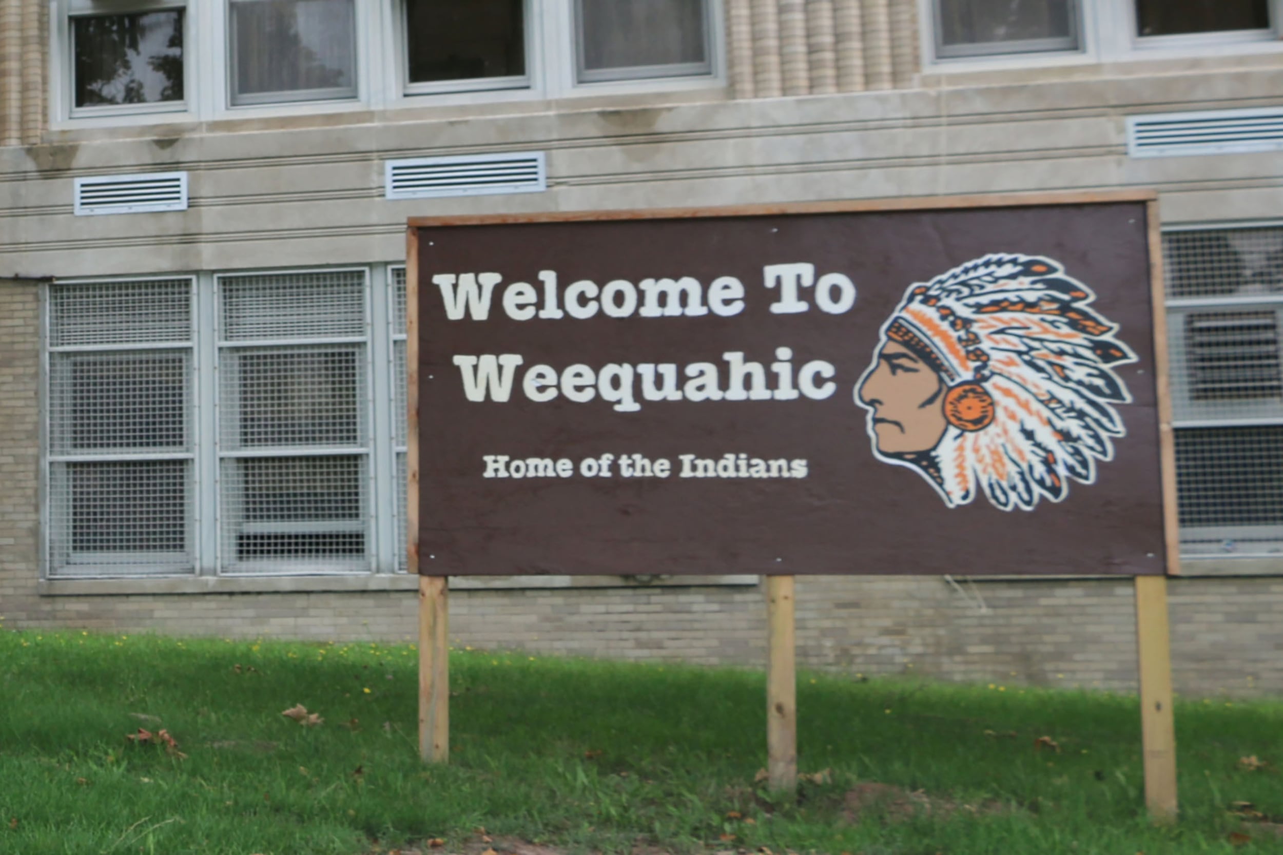 A photograph of a welcome signs with a logo on it.