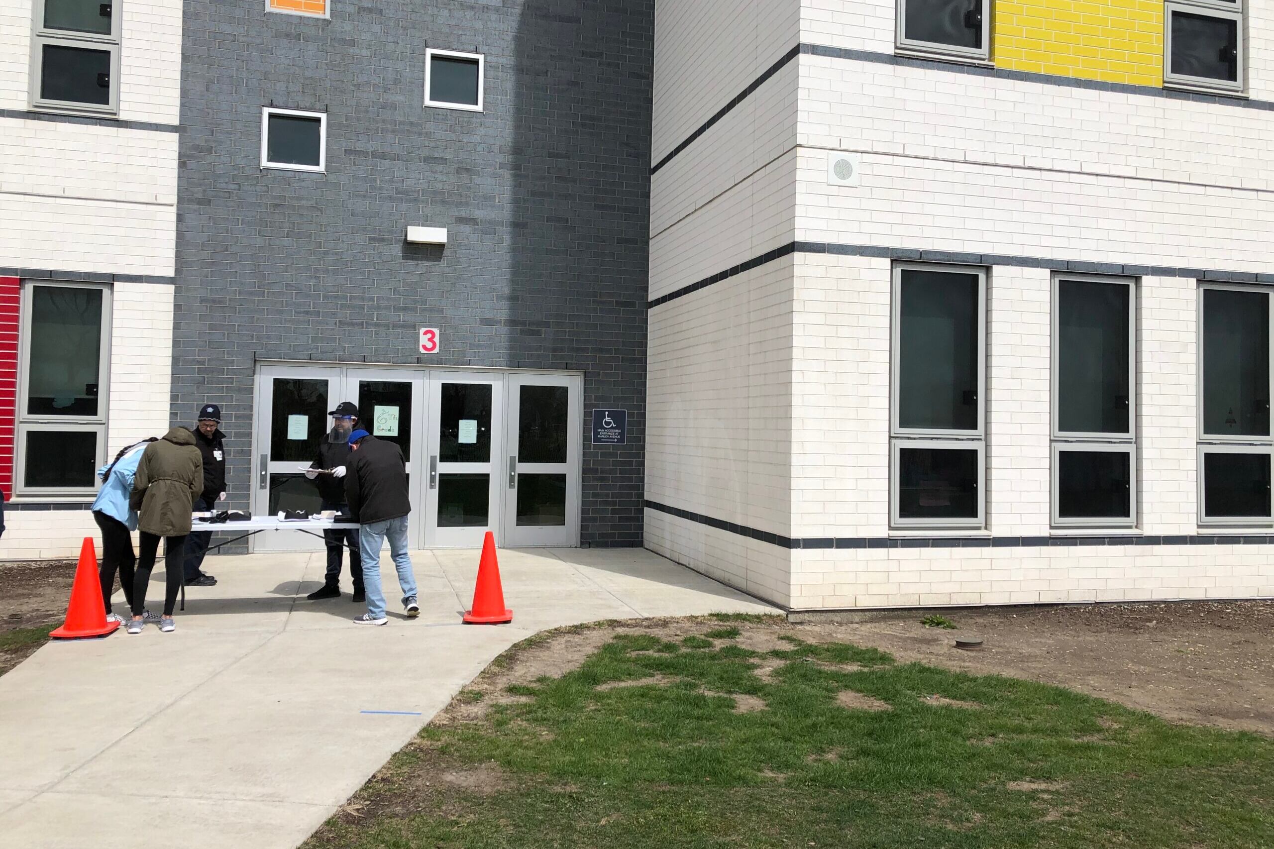 The Padilla sisters pick up loaner Chromebooks outside Richardson Middle School in Chicago on a blustery spring day.