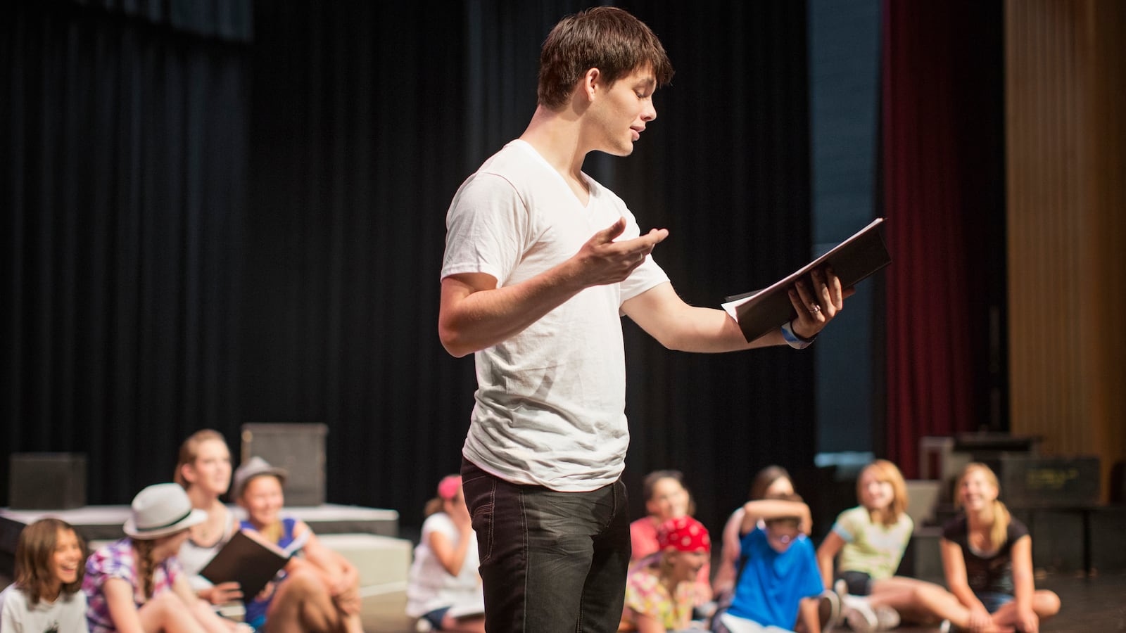Students practicing lines on stage.