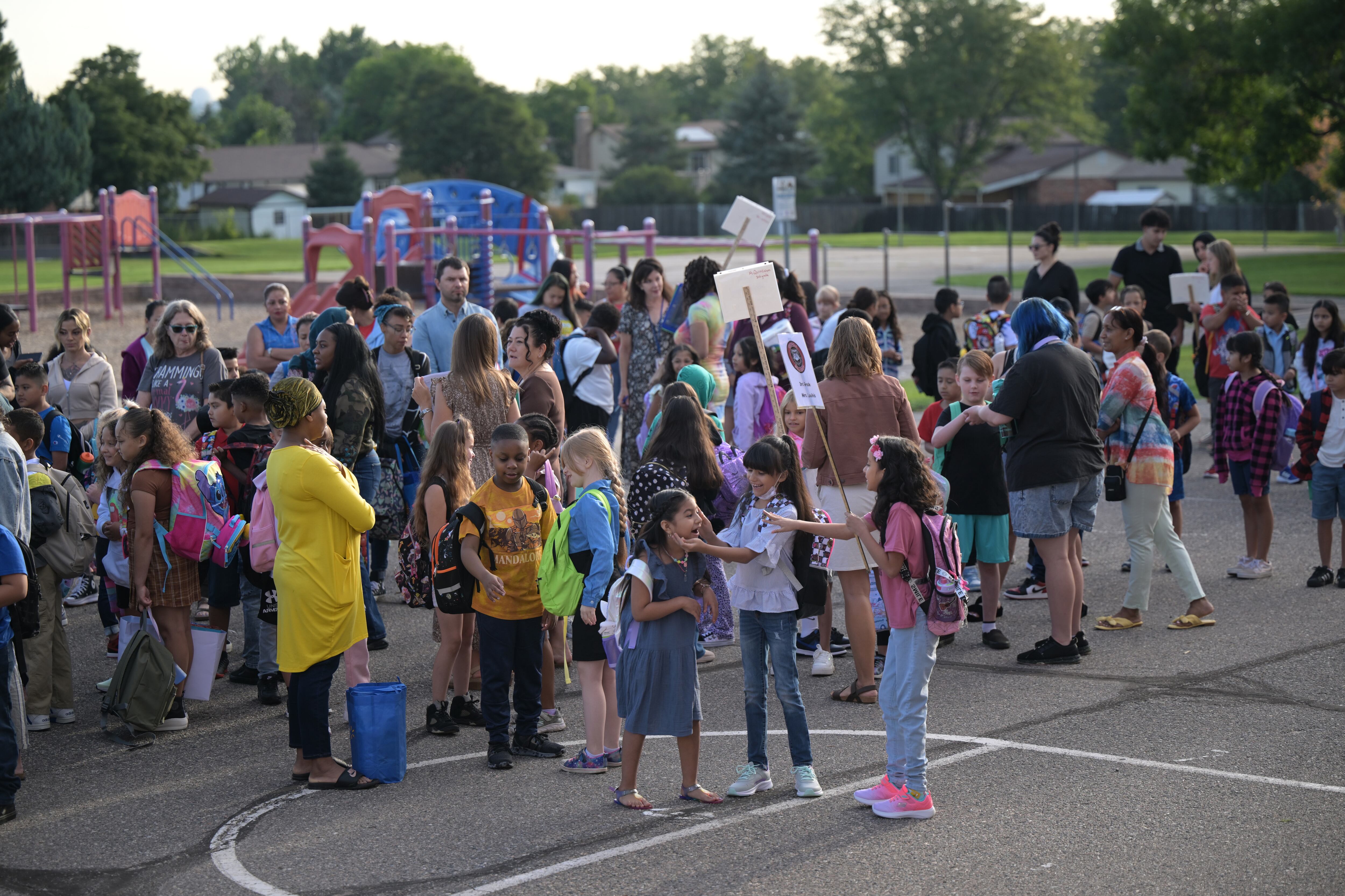 A group of children stand outside.