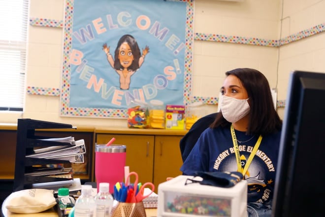 A masked teacher sits at her desk at a Memphis school.