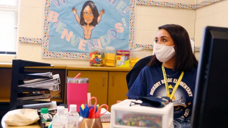 A masked teacher sits at her desk at a Memphis school.