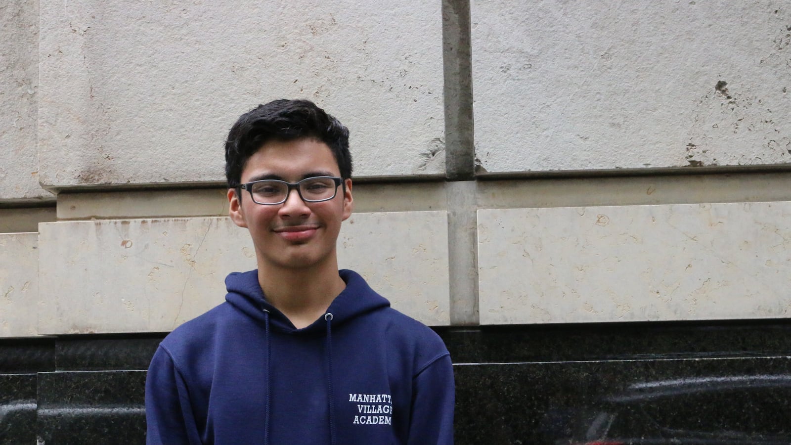 Emmanuel Ruiz stands outside near his high school.