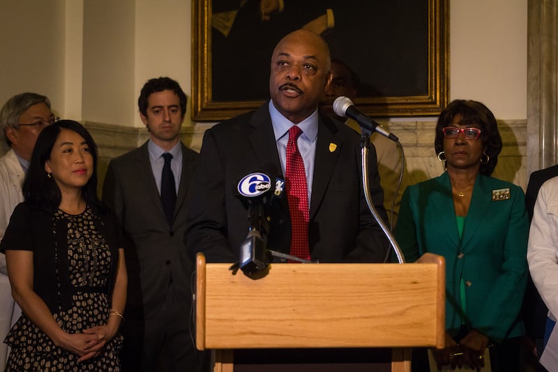 Jerry Jordan standing at a podium speaking into microphones.
