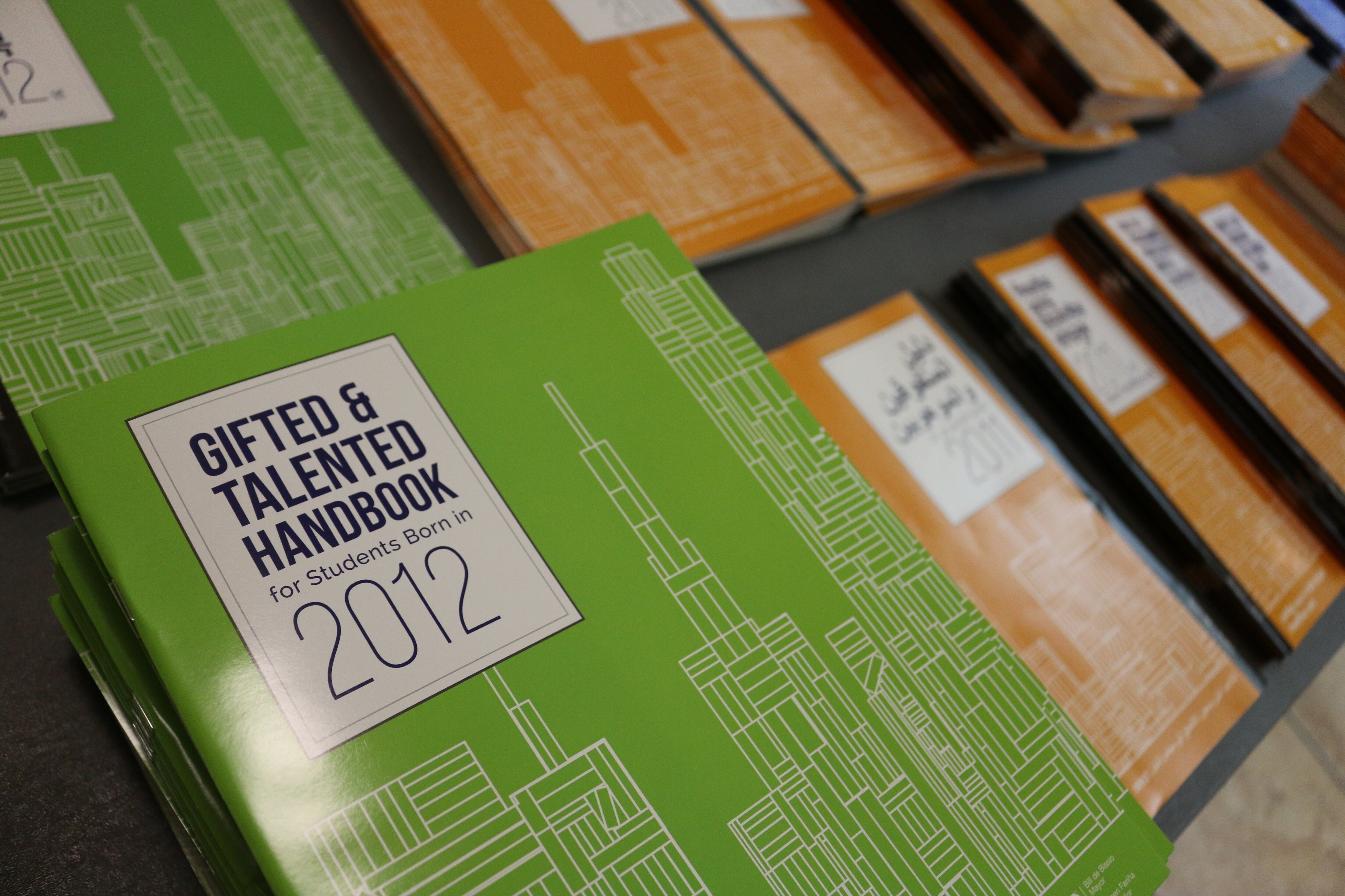A stack of green and orange guides to Gifted and Talented programs from 2012