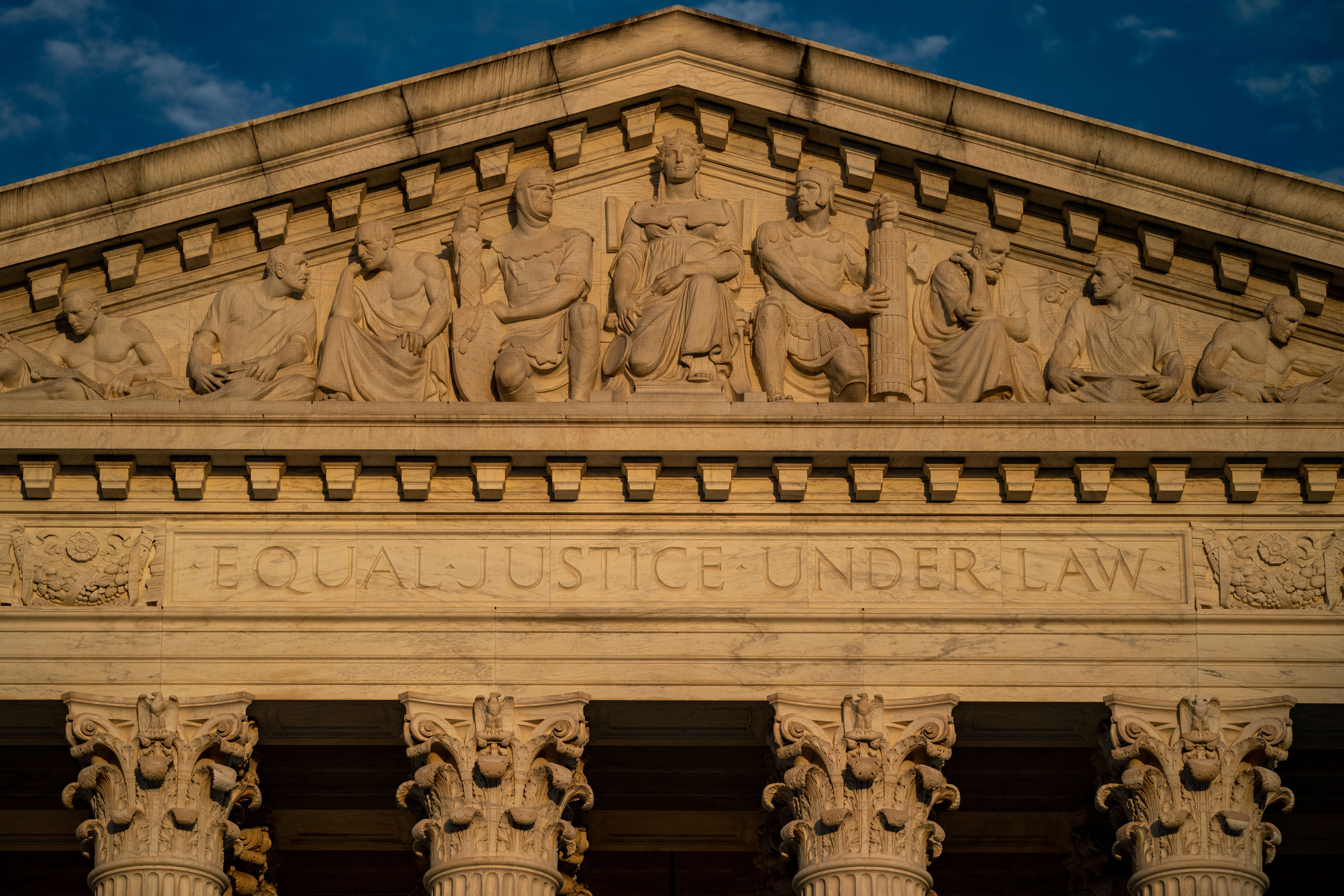 A close up of the top of the U.S. Supreme Court building.