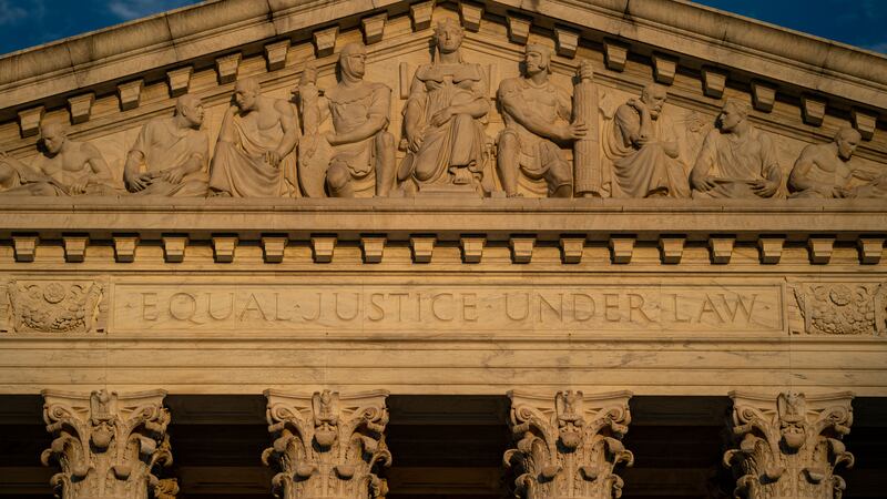 A close up of the top of the U.S. Supreme Court building.