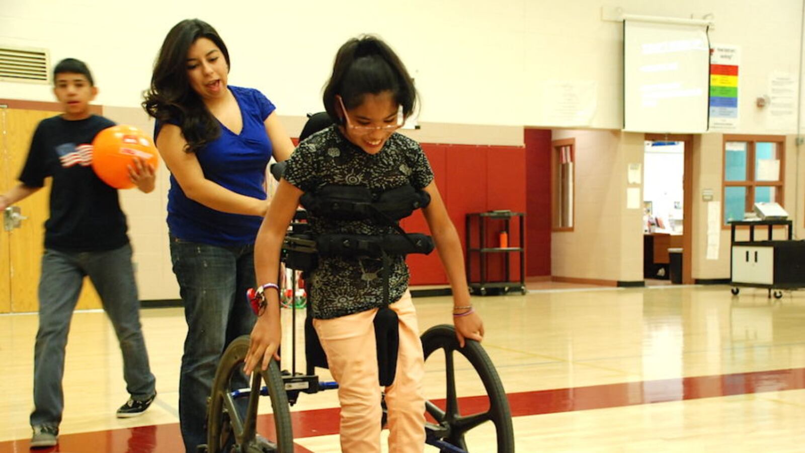 Gabi, a student at Denver's Bruce Randolph School, works with a paraprofessional during an adapted physical education class in 2015.