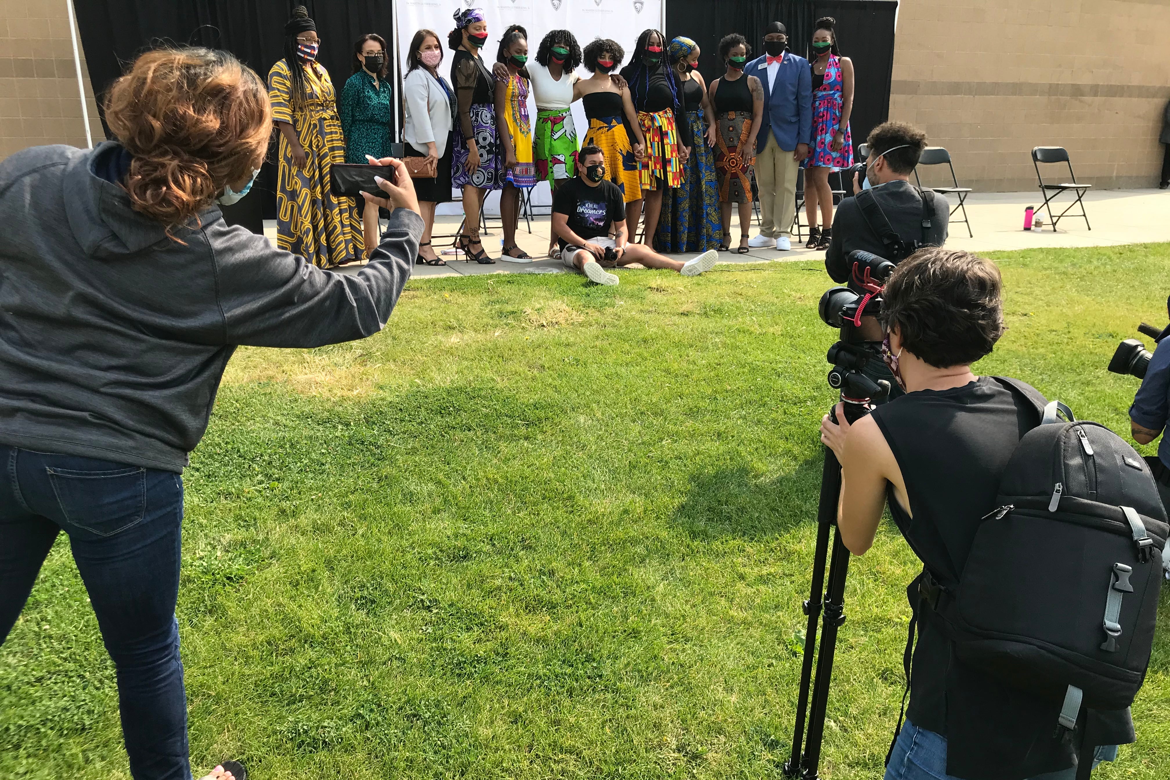 Students smile while media takes photos.